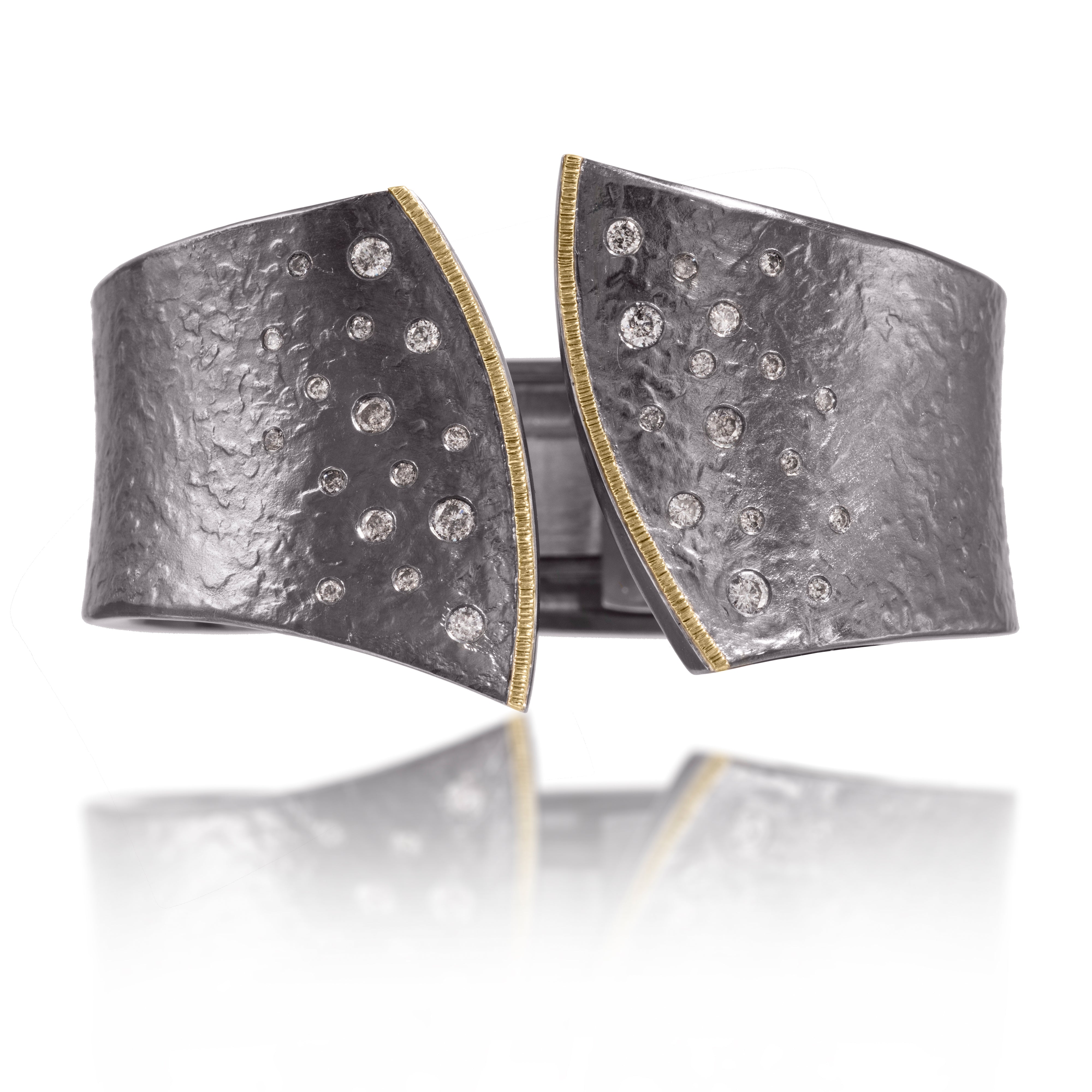 This striking Cyclone Cuff in 18k gold and oxidized silver is flush set with a spray of assorted size diamonds. A hinge on the back side of this tapered cuff allows it to fully open, making it incredibly easy to put on and off with one hand. Symetrical, bypass style, hand fabricated, spring hinged, hammer textured. As shown, 1.00 tcw. Bracelet can be created in one of five different sizes for just the right fit.