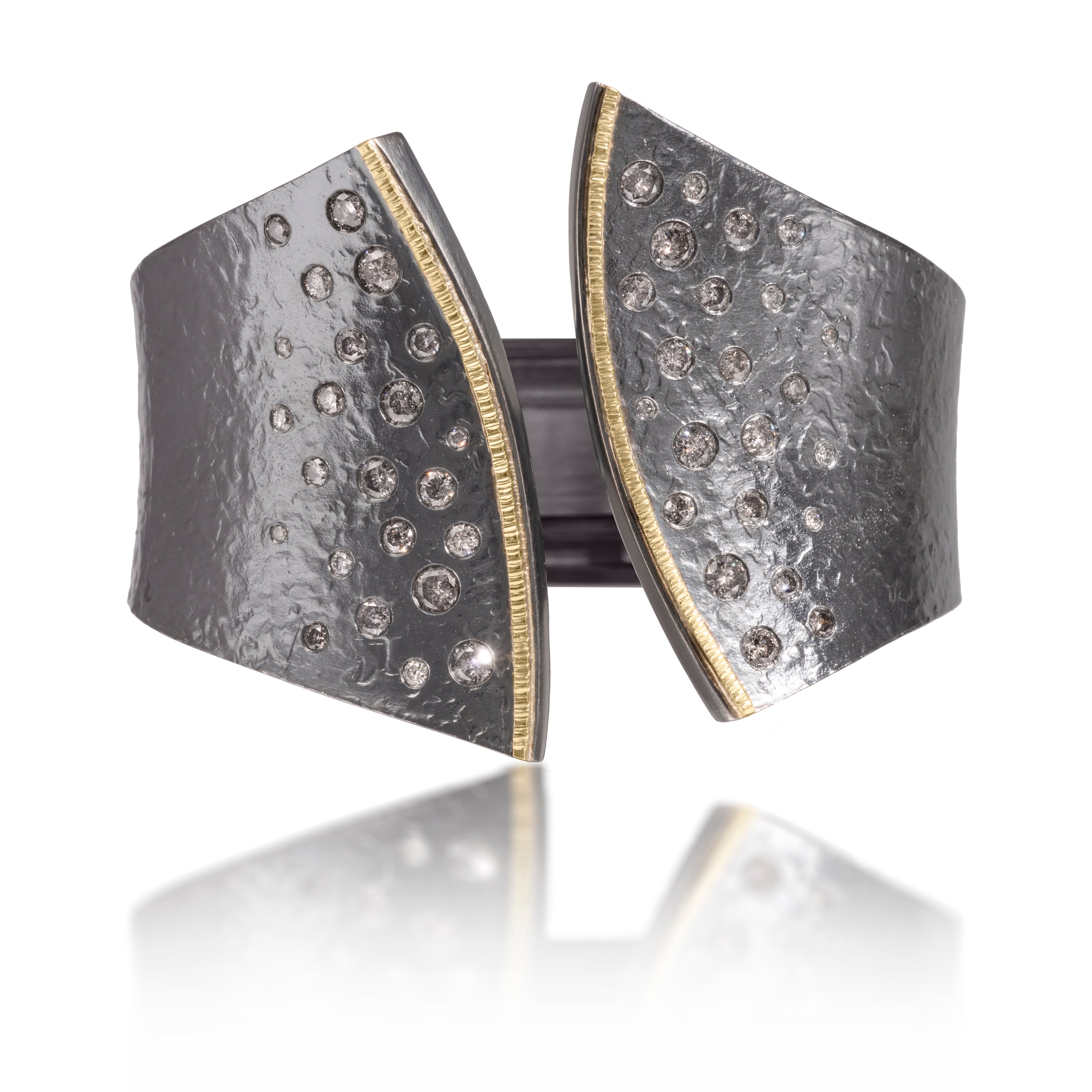 This striking Cyclone Cuff in 18k gold and oxidized sterling silver is flush set with assorted diamonds. A hinge on the back side of this tapered cuff allows it to fully open, making it incredibly easy to put on and off with one hand. Symmetric, bypass style, hand fabricated, spring steel hinge, hammer textured.  Available with white or gray diamonds. As shown, 3.00 tcw. Bracelet can be created in one of five different sizes for just the right fit.