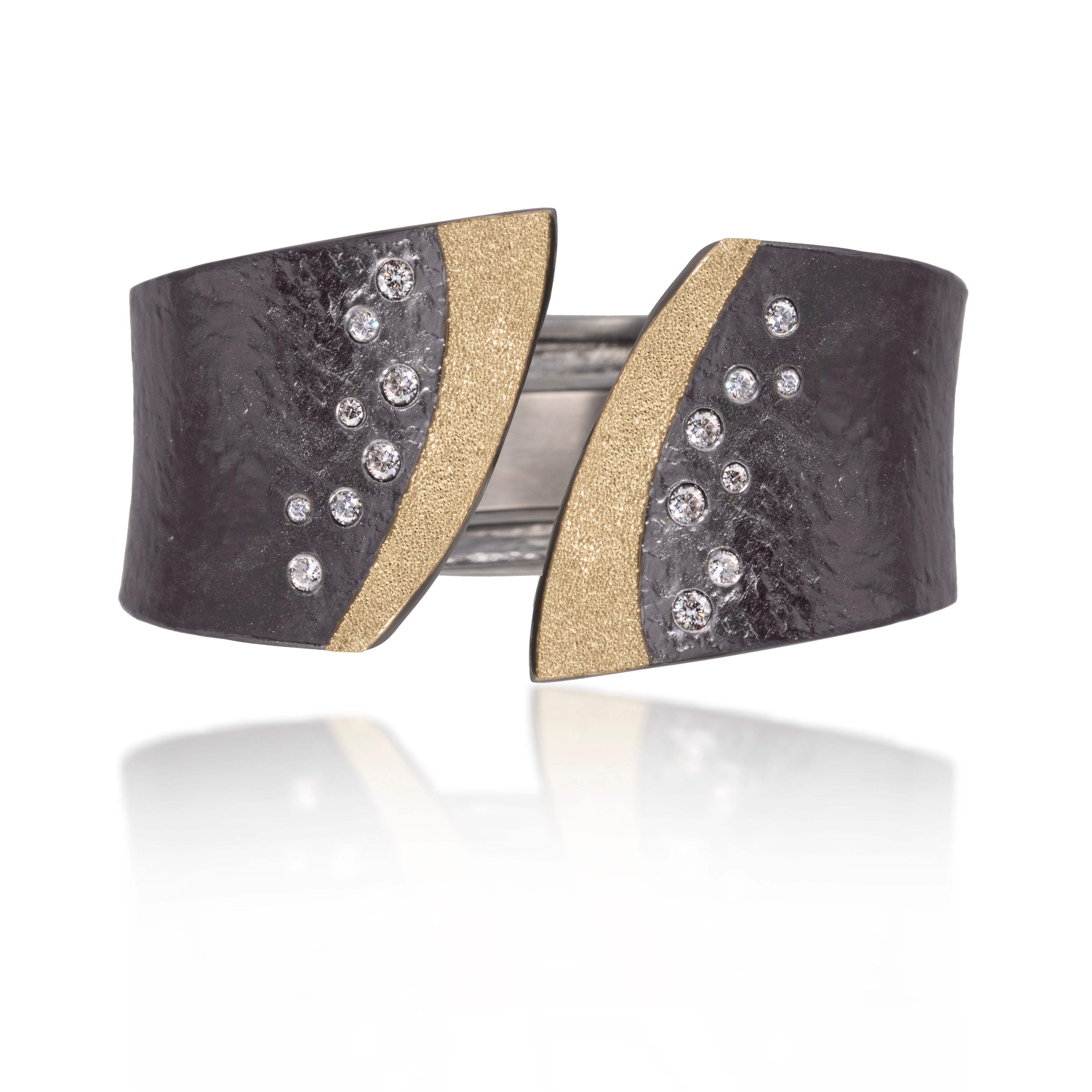 This striking Cyclone Cuff in 18k gold and oxidized sterling silver is flush set with assorted diamonds. A hinge on the back side of this tapered cuff allows it to fully open, making it incredibly easy to put on and off with one hand. Symmetric bypass style, hand fabricated, with a spring steel hinge and hammered textured. Available with white or gray diamonds. As shown, 0.59 tcw.