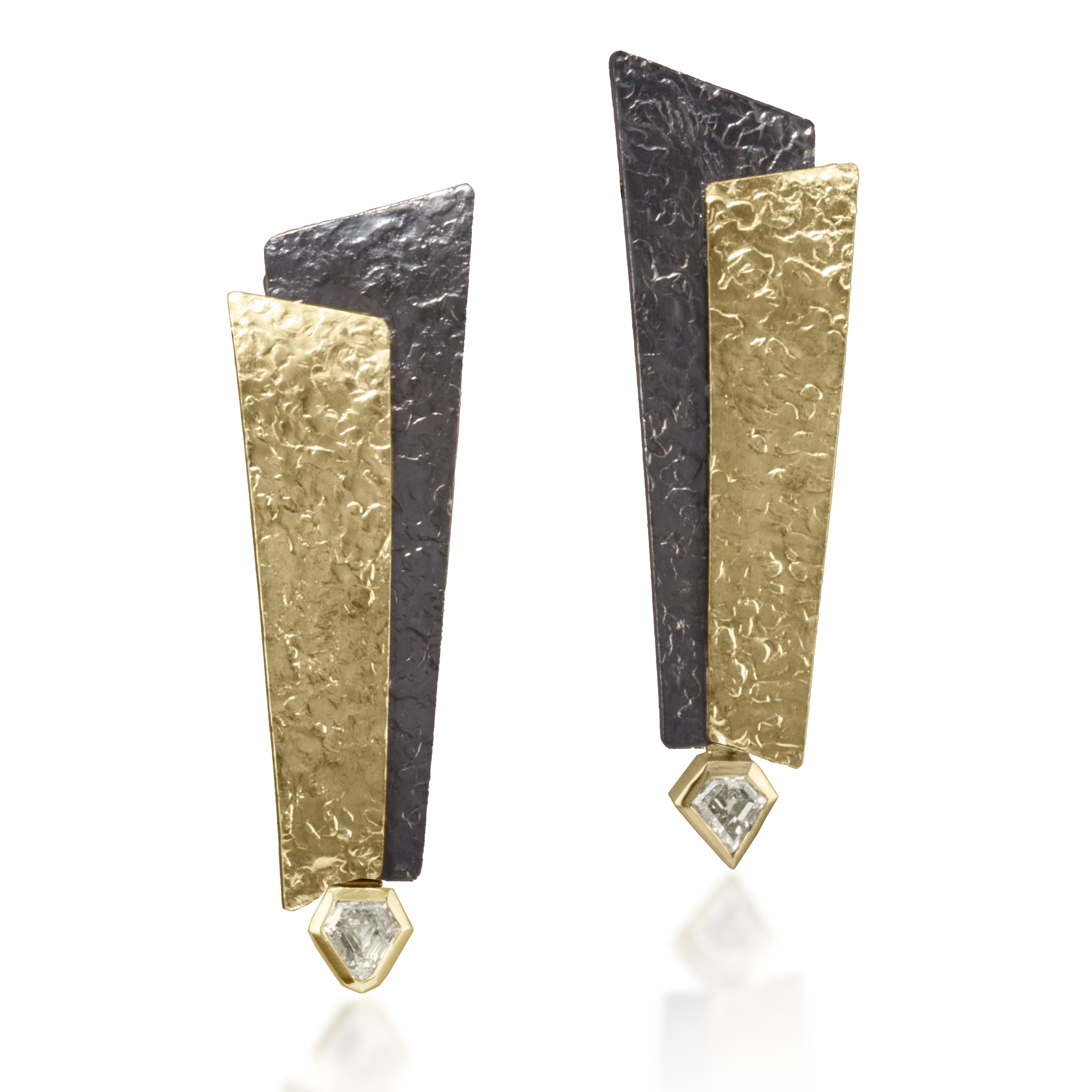 This dramatic earring has been created in 18k bi-metal and oxidized sterling silver accented with various bezel diamonds. Hand fabricated, hammer textured with house fabricated lever backs. tcw. varies by design.