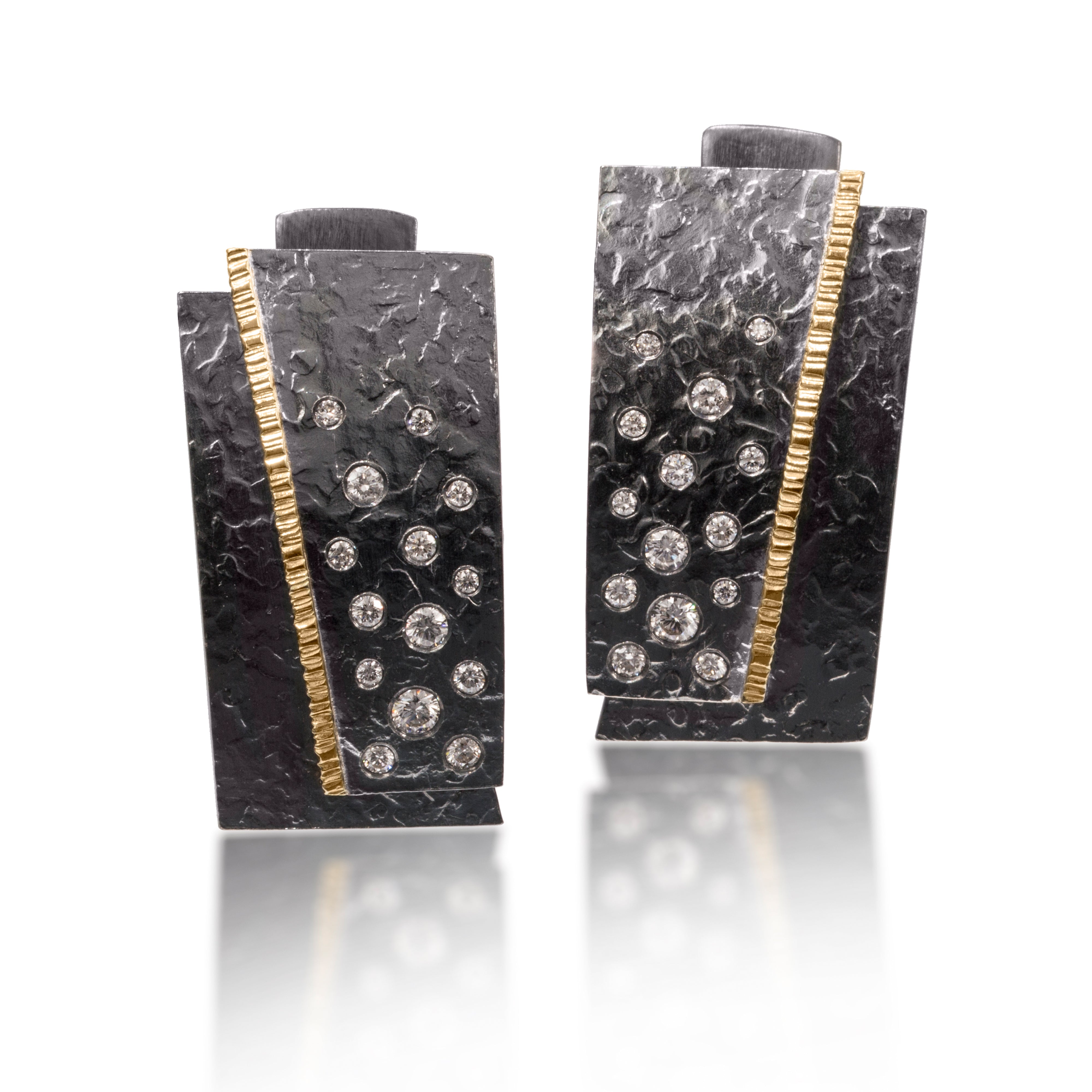 This larger style Cyclone earring in 18k gold and oxidized silver is flush set with natural diamonds. The lever back is comfortable and secure. Hand fabricated, hammer textured. Available in white, yellow or gray diamonds 0.65 tcw.