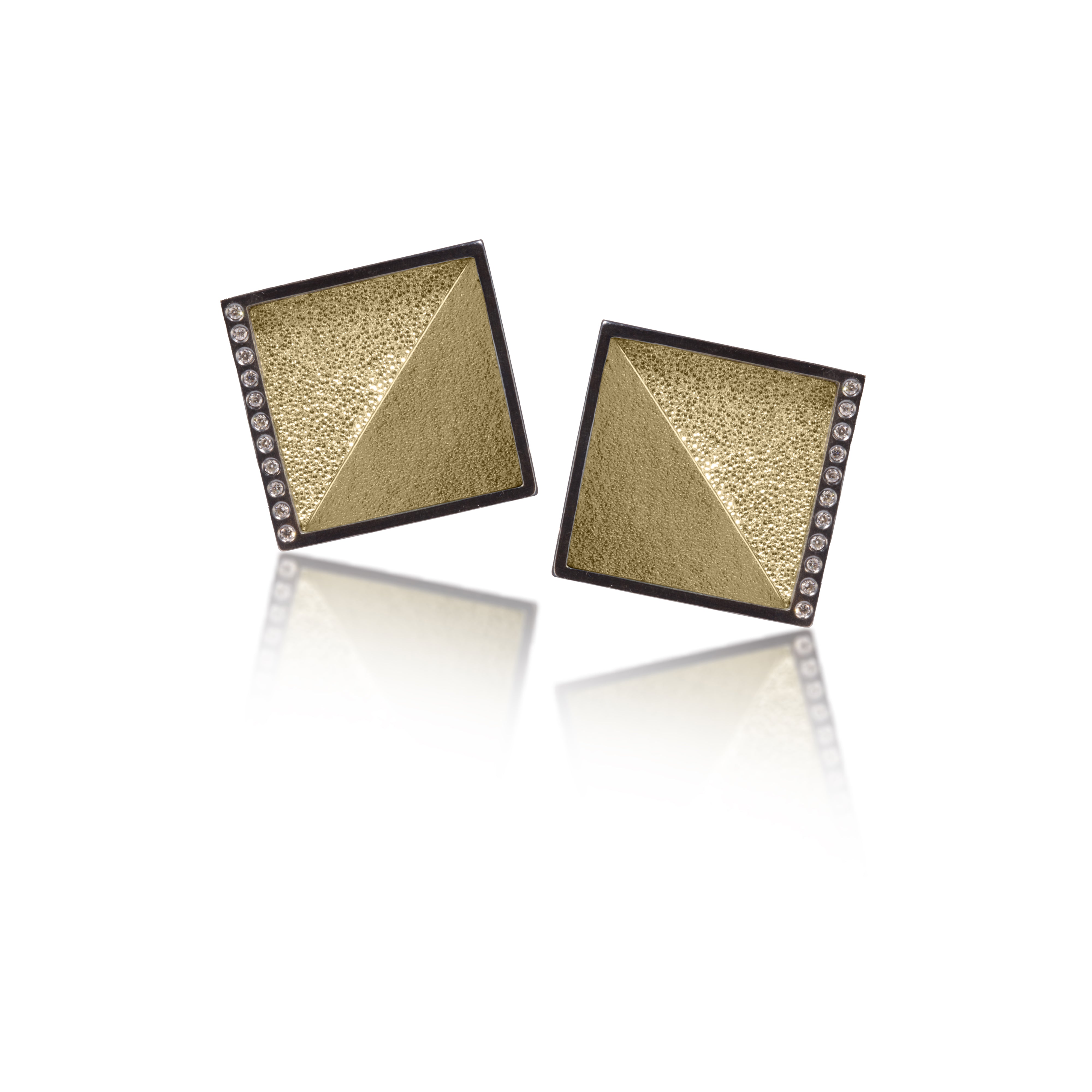 This square post earring in oxidized silver and richly textured 18k bimetal, is flush set with ideal cut white diamonds. It features 14k gold posts. Accent facet glitters with the texture of diamond facets, individually scored and textured. Medium size 0.147 tcw, small size 0.072 tcw.