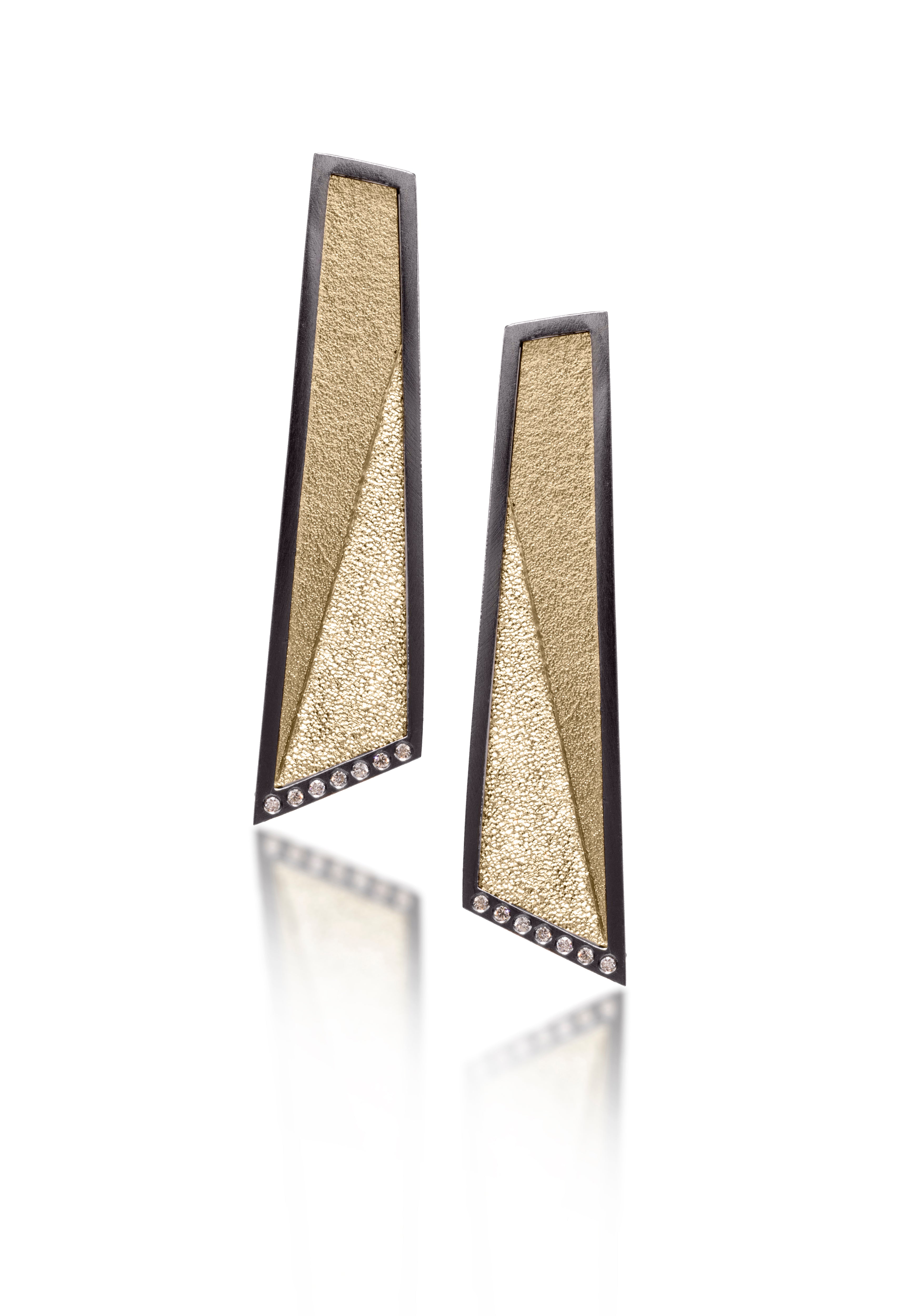 This earring in oxidized sterling silver and richly textured 18k bimetal, is flush set with ideal cut white diamonds. It features 14k gold posts or 18k gold ear wires. Accent facet glitters with the texture of diamond facets, individually scored and textured. Elongated shape, size large. Available in post, post fringe, drop and drop fringe styles.  0.0966 tcw