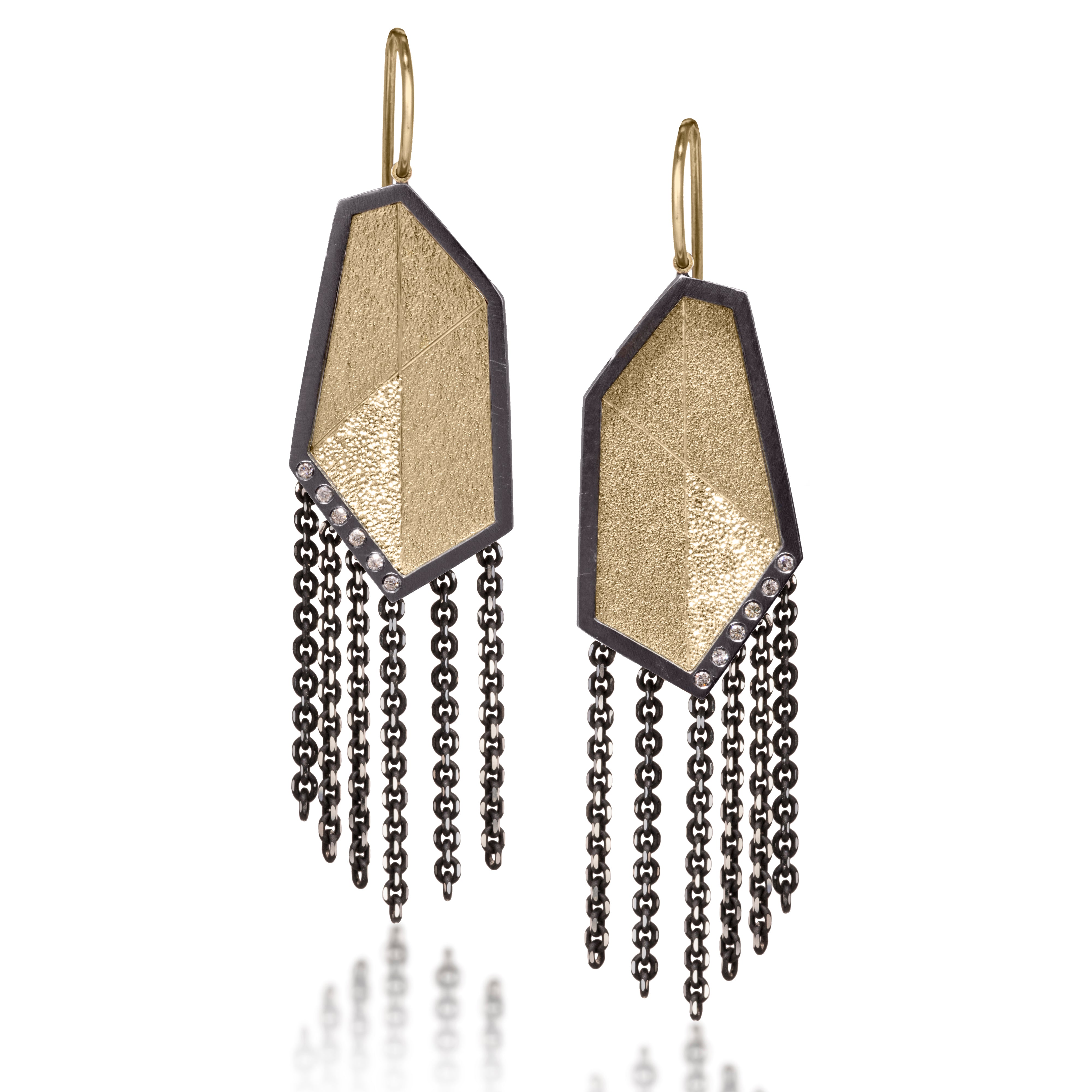 This earring is created with oxidized sterling silver and richly textured 18k bimetal, flush set with ideal cut white diamonds. It features 14k gold posts or 18k gold ear wires. Accent facet glitters with the texture of diamond facets, individually scored and textured. Elongated shape, size medium. Available in post, post fringe, drop or drop fringe styles. 0.0828 tcw
