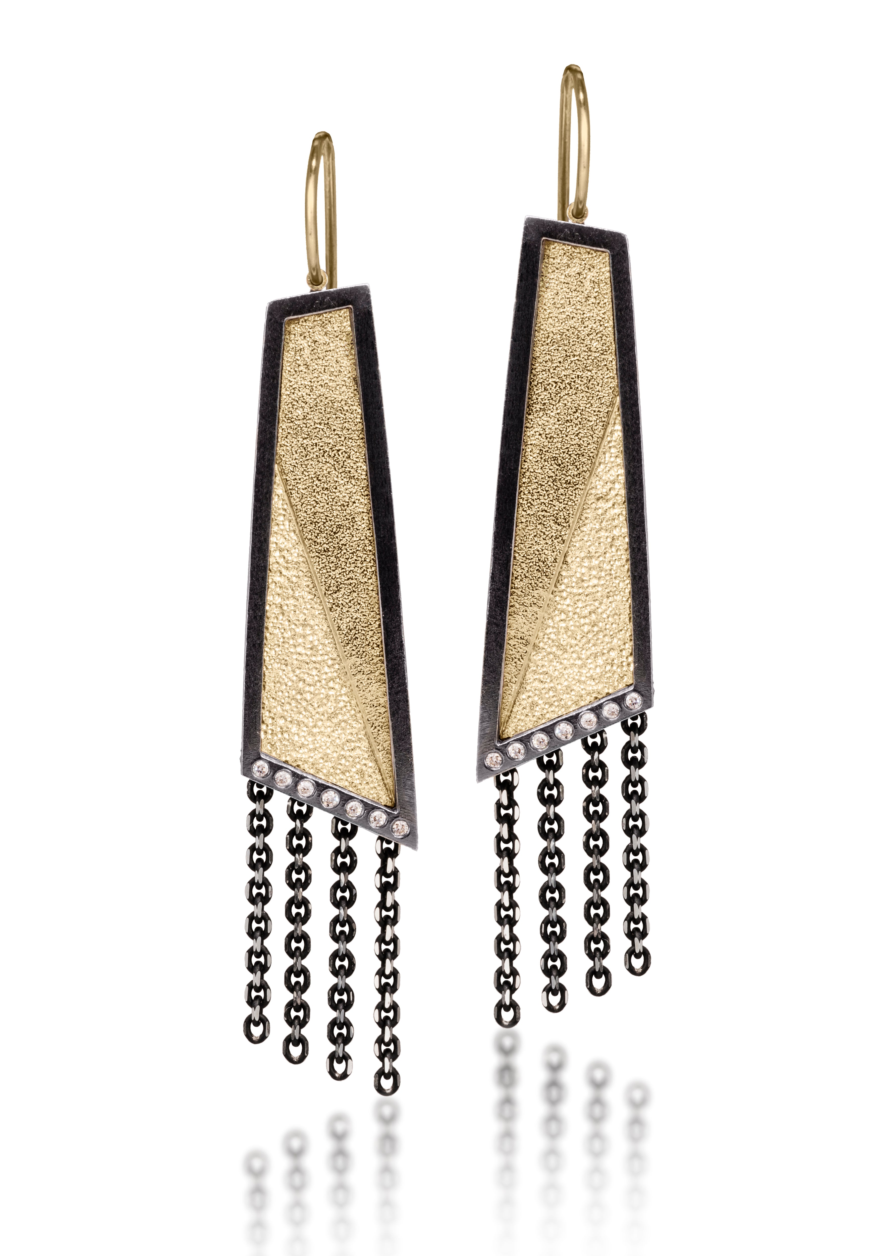 This earring in oxidized sterling silver and richly textured 18k bimetal, is flush set with ideal cut white diamonds. It features 14k gold posts or 18k gold ear wires. Accent facet glitters with the texture of diamond facets, individually scored and textured. Elongated shape, size medium. Available in post, post fringe, drop and drop fringe styles. 0.0966 tcw