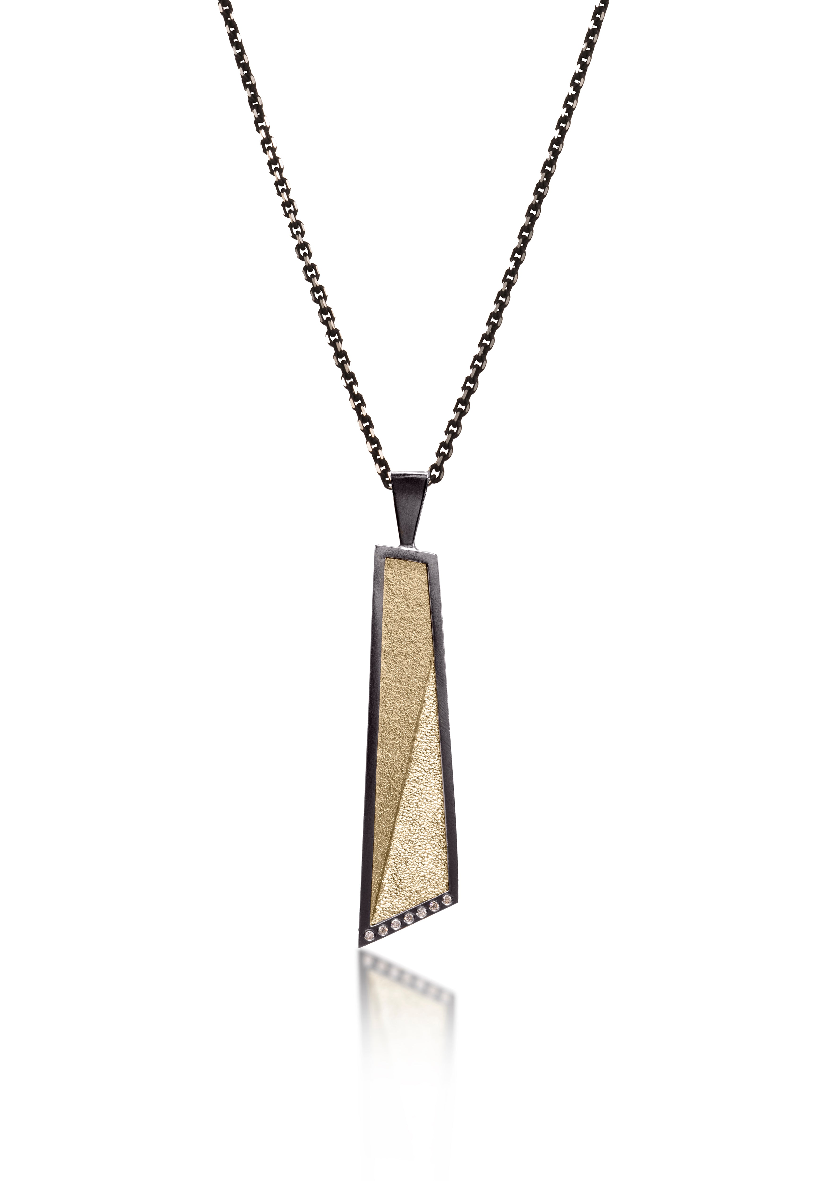 This oxidized sterling silver and richly textured 18k bimetal pendant is flush set with ideal cut white diamonds.  Accent facet glitters with the texture of diamond facets, individually scored and textured.  Elongated shape in longest length, available with or without diamond cut chain fringe. 0.0483 tcw 