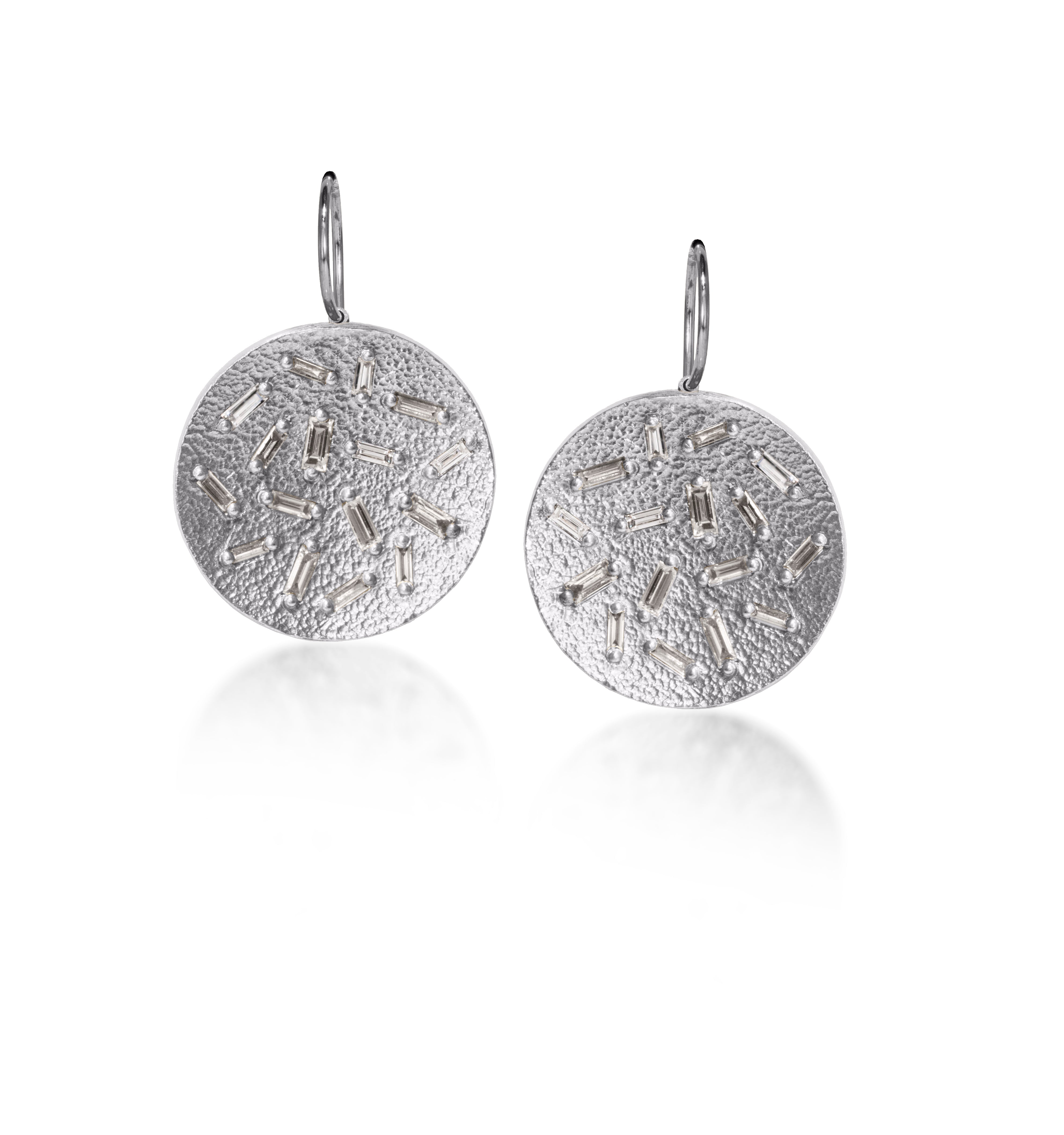 This simple but dramatic drop earring is perfect for everyday. Offered in three richly textured color ways, oxidized sterling, 18k gold, palladium. Each earring set with 16 white diamond baguettes. 0.87 tcw.
