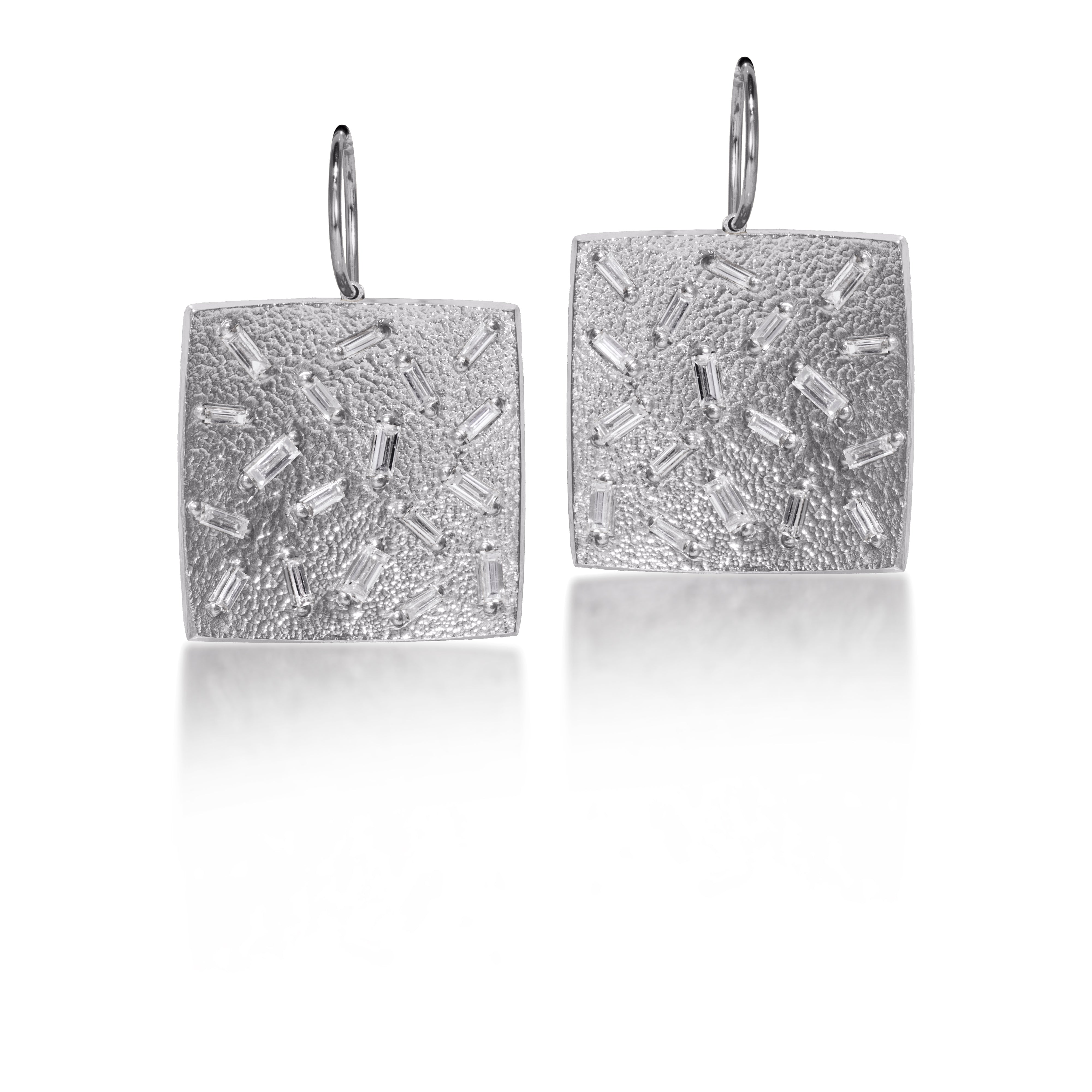 This medium size, simple but dramatic post earring is perfect for everyday or a fabulous night out.  Offered in three richly textured color ways, oxidized sterling, 18k gold, palladium.  Each earring set with 18 white diamond baguettes.  0.972 tcw.