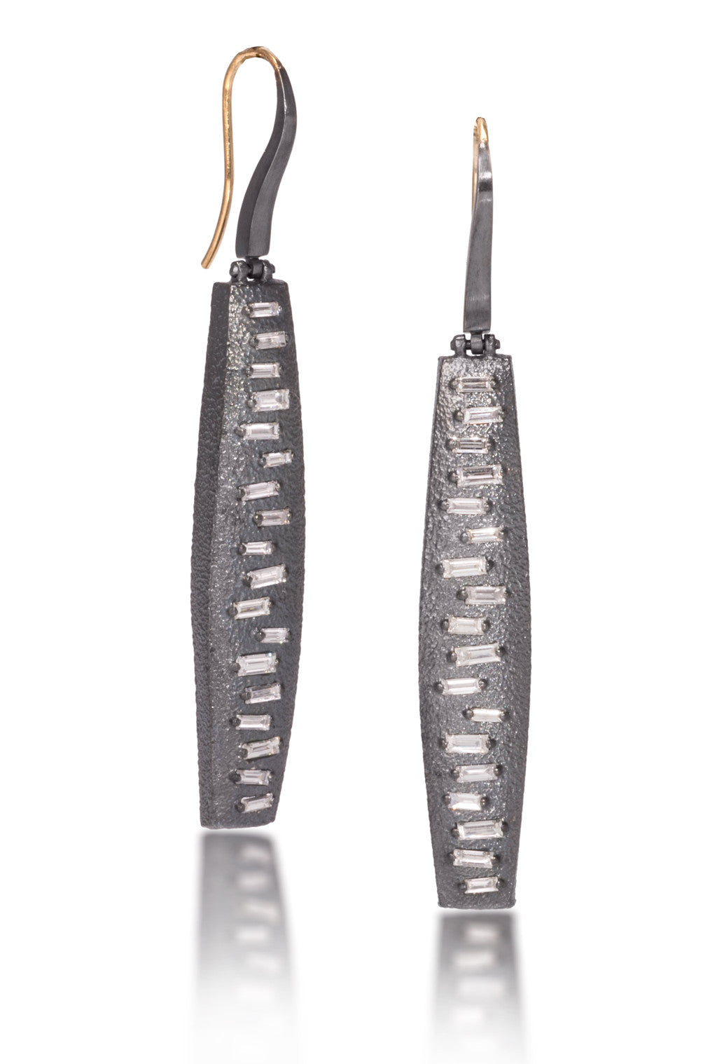 This earring features a hinged earwire, with a graceful, curved and tapered form. The playful irregularity of the baguette angles catch the light in dynamic ways. Design is offered in four richly textured colorways, oxidized sterling, oxidized sterling/18k gold, 18k gold and palladium.  Each earring set with 36 total white diamond baguettes. 1.1104 tcw.