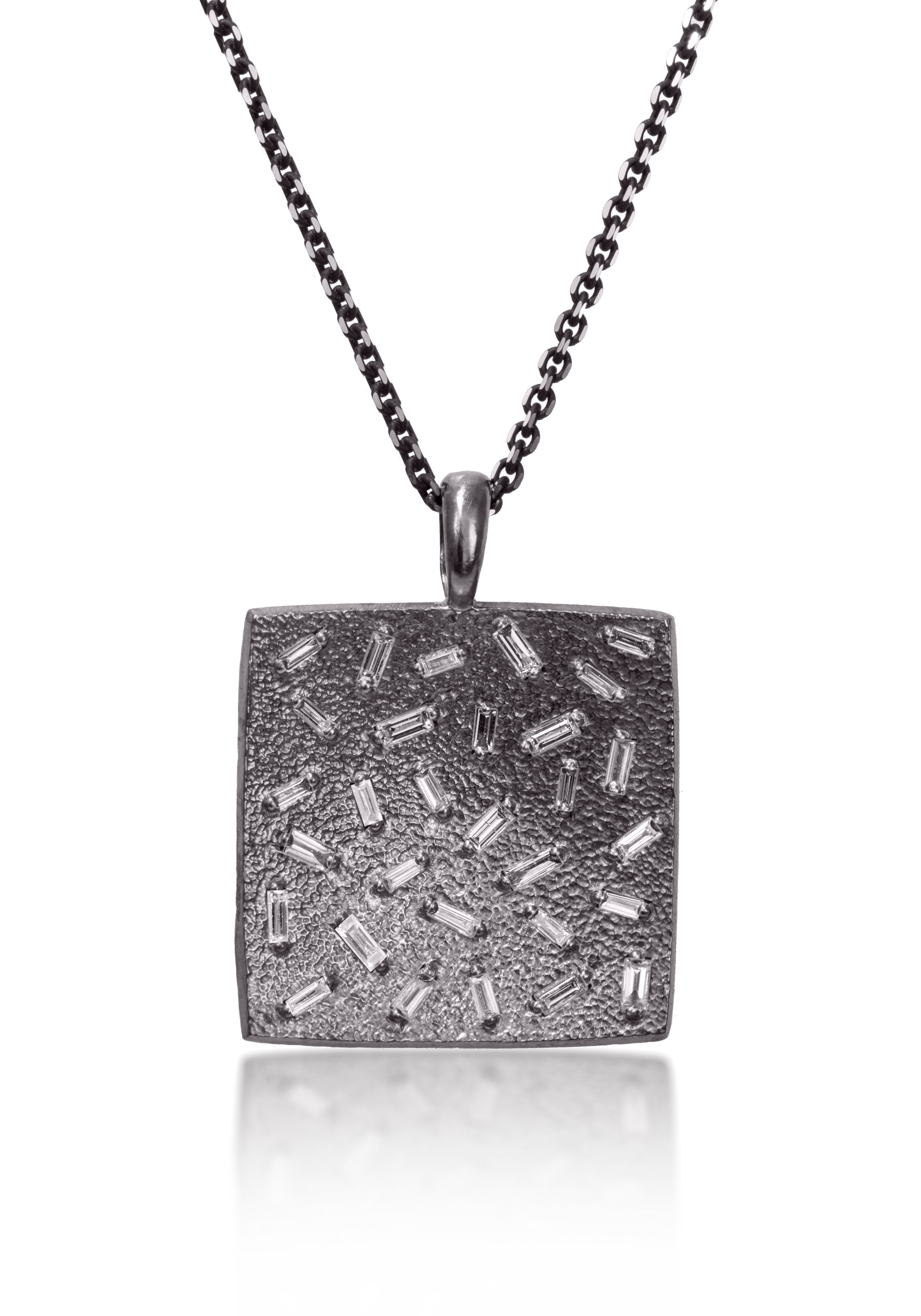 This larger square pendant features a stunning 30 white diamond baguettes. Richly textured, generous bail fits a wide range of chains. Available in three color ways, oxidized silver, 18k gold and palladium.  Price includes pendant only.  0.824 tcw.  