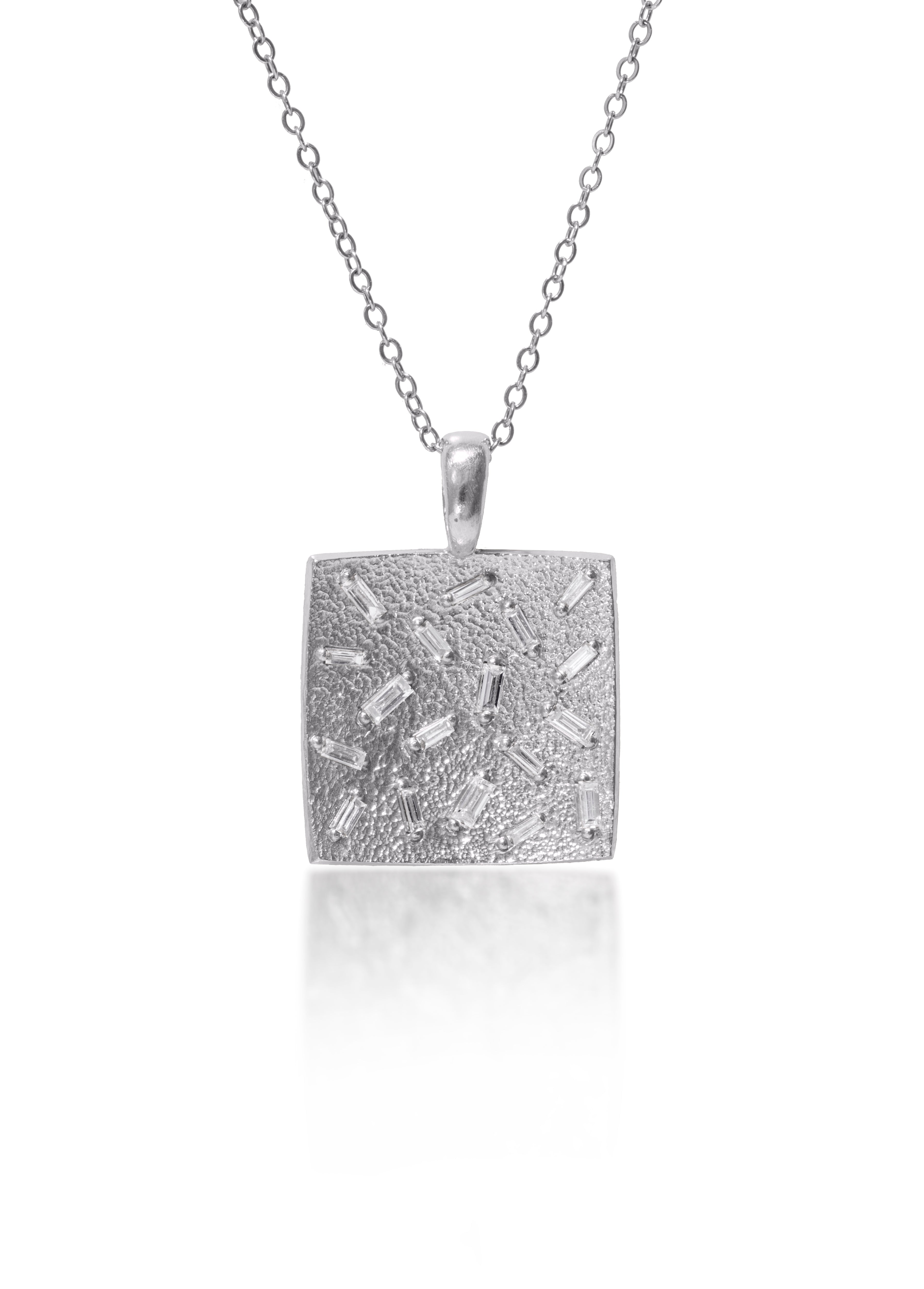This medium size square pendant is set with 18 white diamond baguettes. Richly textured to shimmer in the light, this piece is available in three color ways, oxidized silver, 18k gold and palladium. 0.486 tcw.