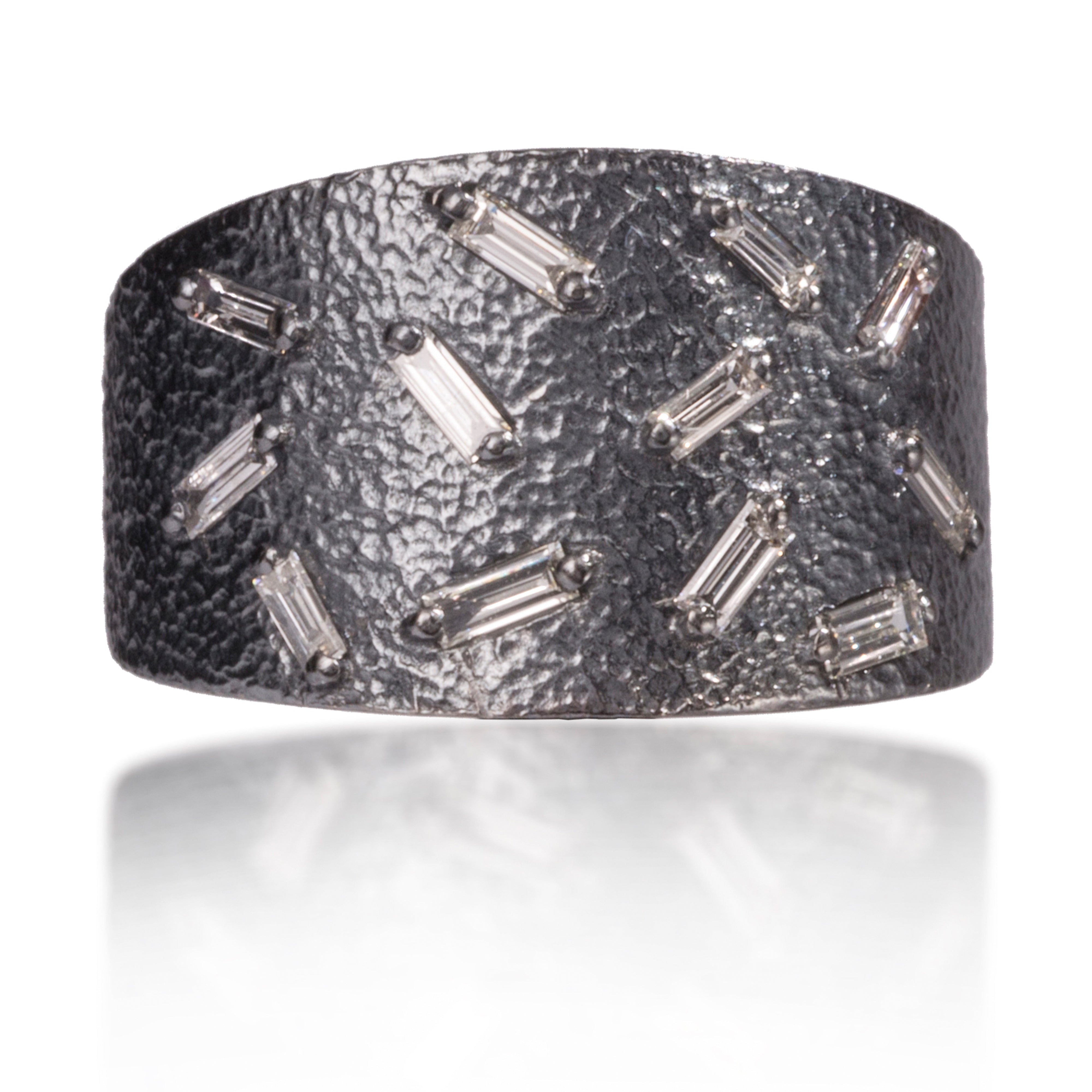 This medium width cigar band style ring is set with 12 white diamond baguettes. It is available in three richly textured color ways, oxidized silver, 18k gold, and palladium. Makes a beautiful bridal alternative. 0.4023 tcw. 