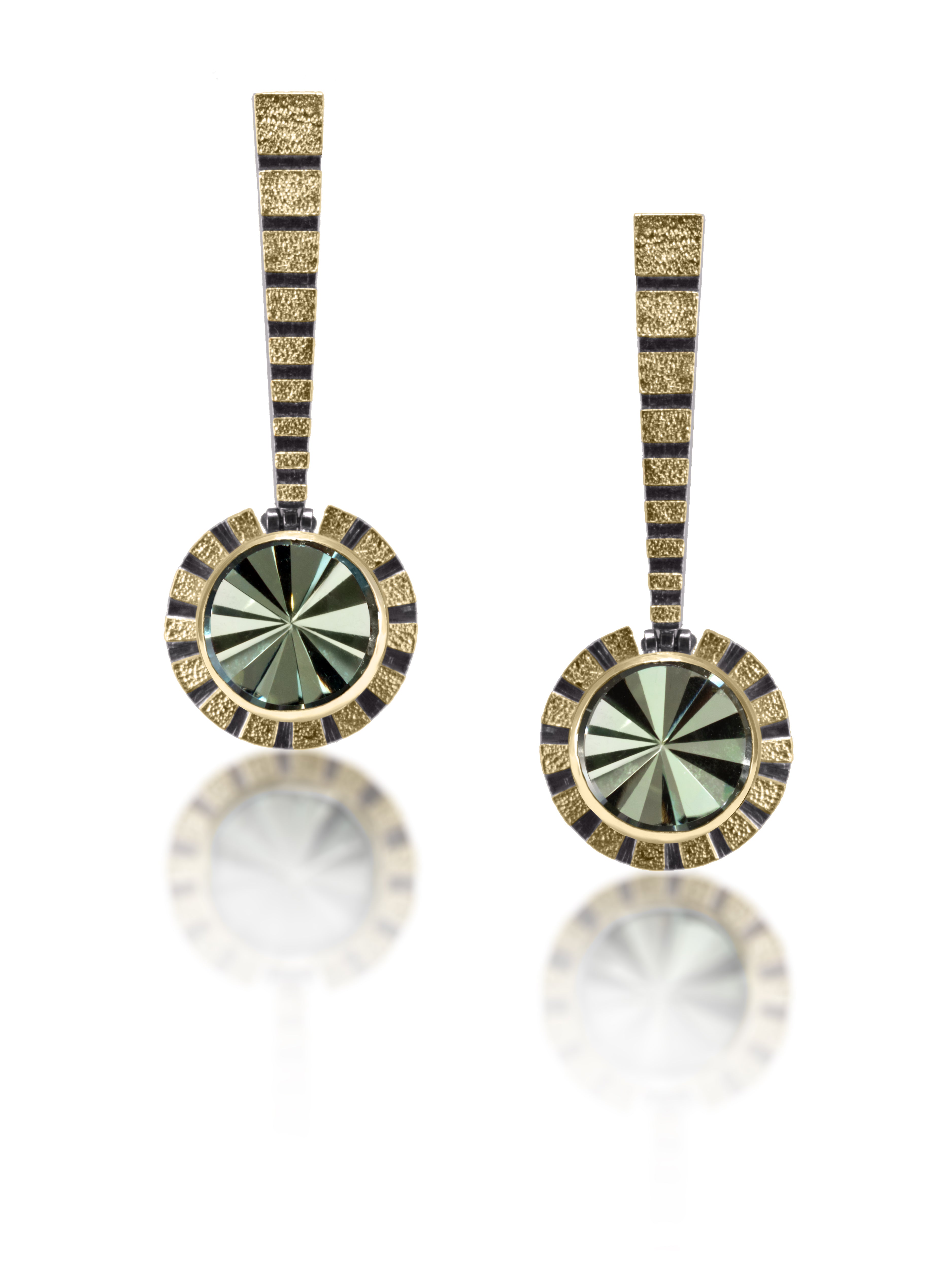 This radiant (literally) Stripe Earring #2 catches light from every angle. Created in 18k gold and oxidized sterling silver, the design features a bezel set, radial cut, semiprecious center stone. Hand fabricated, stipple textured and engraved mixed metals. The circular pendants hang from a hinged, tapered bar with graduated stripes and 14k gold posts.
