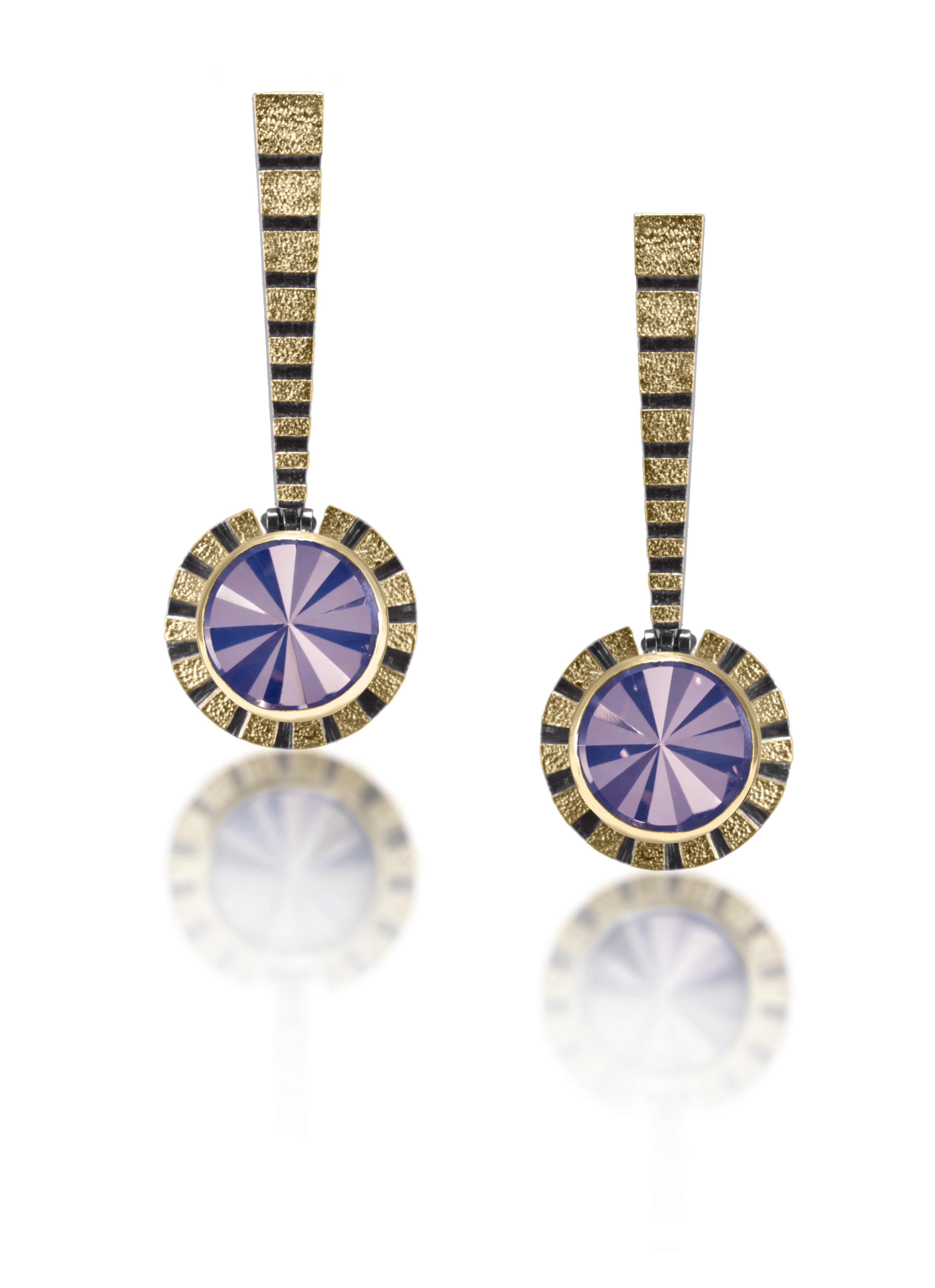 This radiant (literally) Stripe Earring #2 catches light from every angle. Created in 18k gold and oxidized sterling silver, the design features a bezel set, radial cut, semiprecious center stone. Hand fabricated, stipple textured and engraved mixed metals. The circular pendants hang from a hinged, tapered bar with graduated stripes and 14k gold posts.