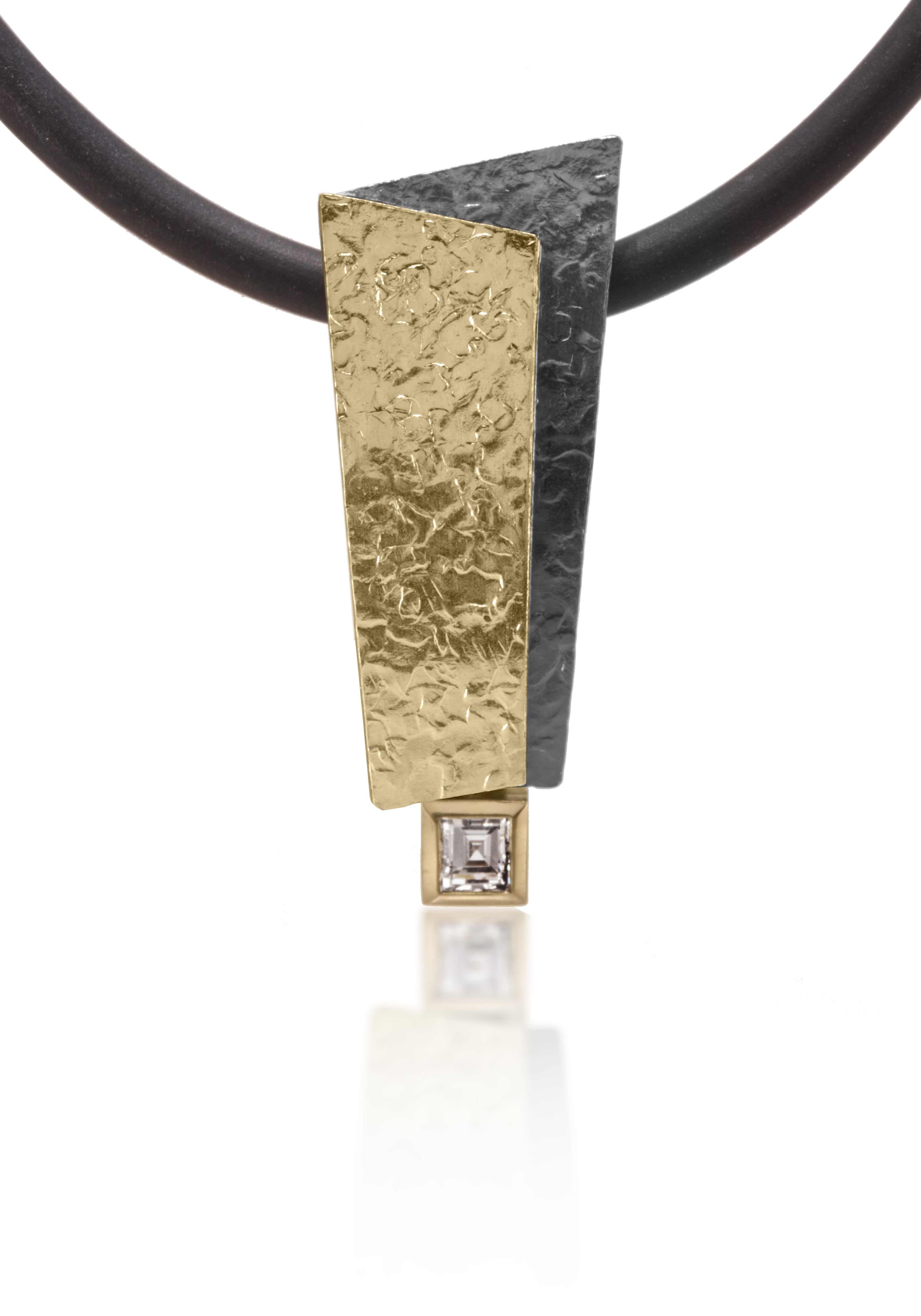This Cyclone Pendant in 18k gold, 18k bimetal and oxidized silver offers a stunning contrast of precious metals.  This statement piece culminates with a bezel set white carré cut 0.28ct rectangular diamond. Entirely hand fabricated, hammer textured. Shown on a 3mm rubber cord, not included.