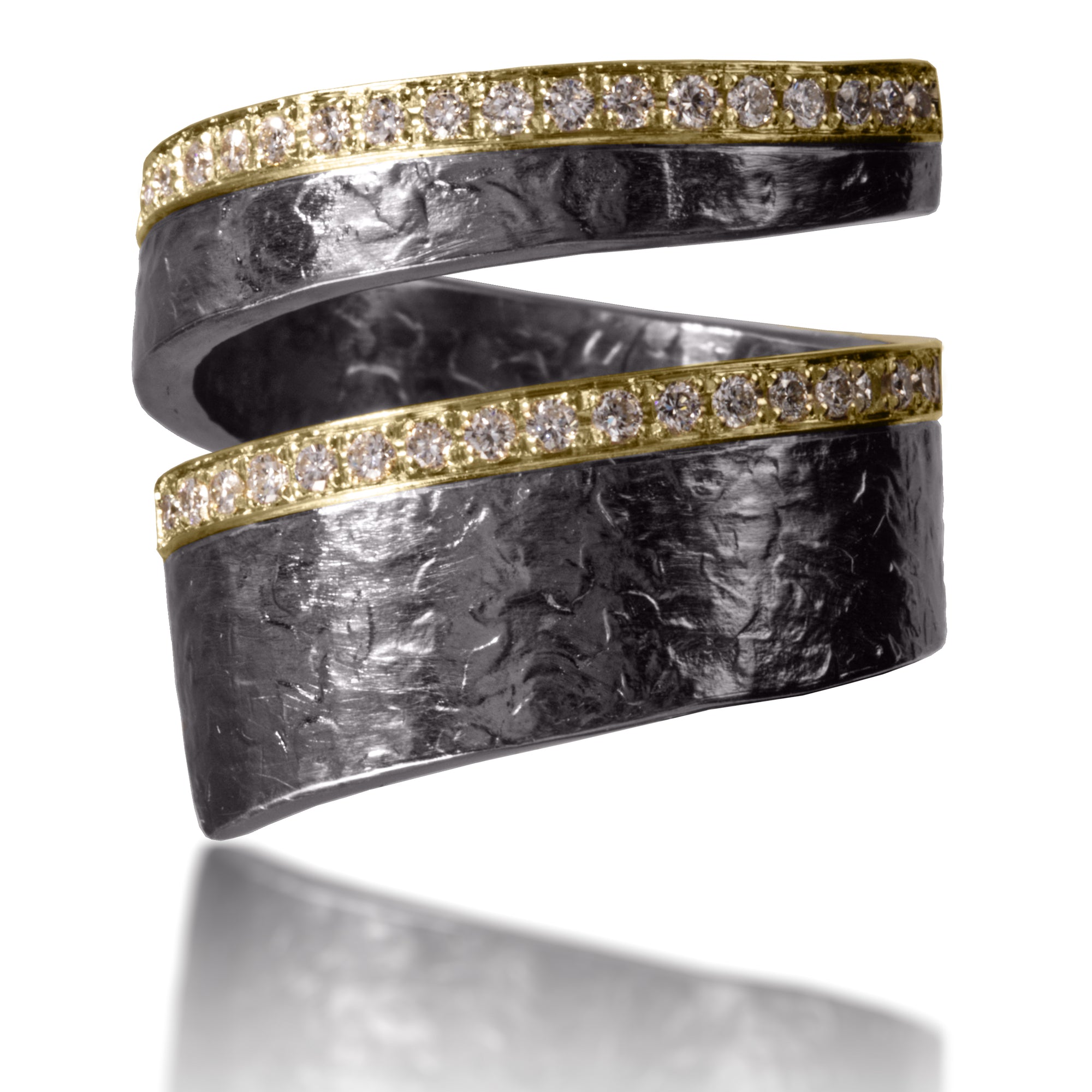 The iconic Cyclone ring, wrapping diamonds around your finger like a miniture twister. Combining earthy textured metals with true bright cut pavé, 36 white diamonds twinkle with the fierceness of the sun. Hand forged and fabricated in 18k gold and oxidized sterling silver. As shown, 0.32 tcw.