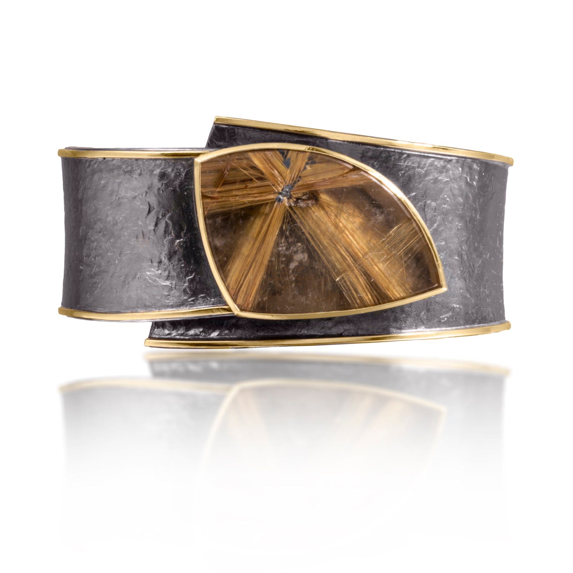 This one-of-a-kind Cyclone Cuffs in 18k gold and oxidized silver is bezel set with a large, star Rutilated Quartz. A hinge on the back side of this tapered cuff allows it to fully open, making it incredibly easy to put on and off with one hand. Wide, wrap-around style cuff, hand fabricated, spring steel hinge, hammer textured. Rutilated Quartz 48.34 tcw.