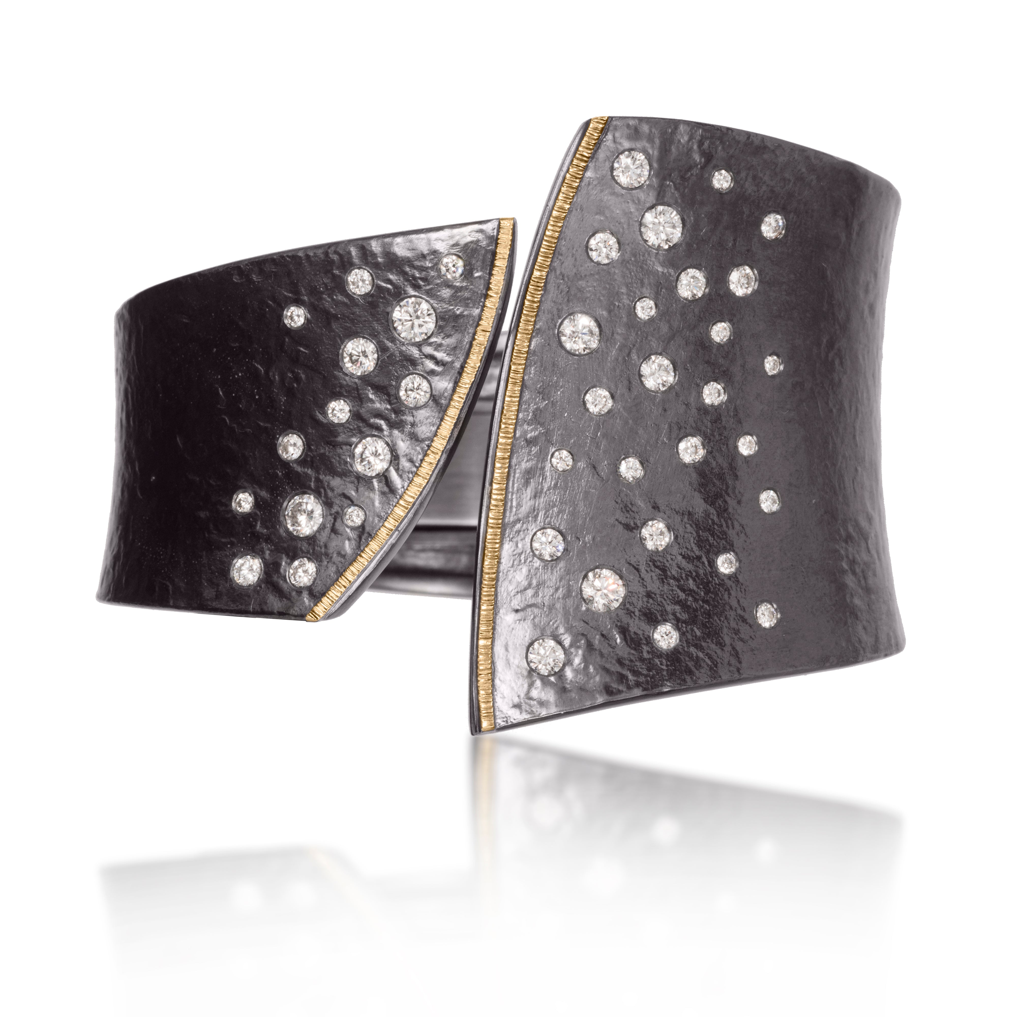 This striking Cyclone Cuff in 18k gold and oxidized sterling silver is flush set with assorted diamonds.  A hinge on the back side of this tapered cuff allows it to fully open, making it incredibly easy to put on and off with one hand.  Asymmetric, bypass style, hand fabricated, spring steel hinge, hammer textured.  Available with white or gray diamonds.  As shown, 2.00 tcw. size medium. 