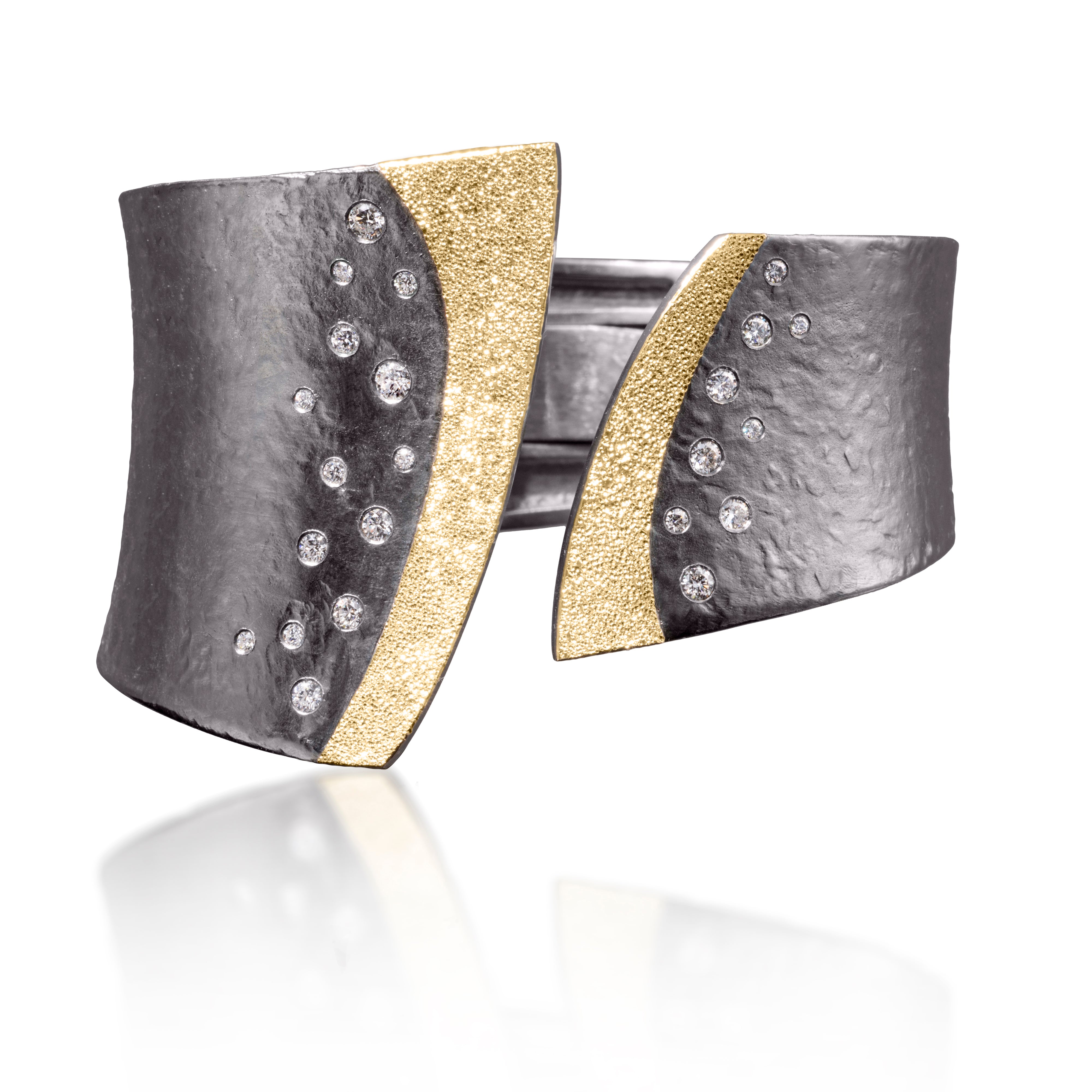 This striking Cyclone Cuff in 18k gold and oxidized sterling silver is flush set with assorted diamonds. A hinge on the back side of this tapered cuff allows it to fully open, making it incredibly easy to put on and off with one hand.  Symmetric or asymmetric, bypass style, hand fabricated, with a spring steel hinge and hammered textured. Available with white or gray diamonds.  As shown 0.78 tcw | Elizabeth Garvin FINE