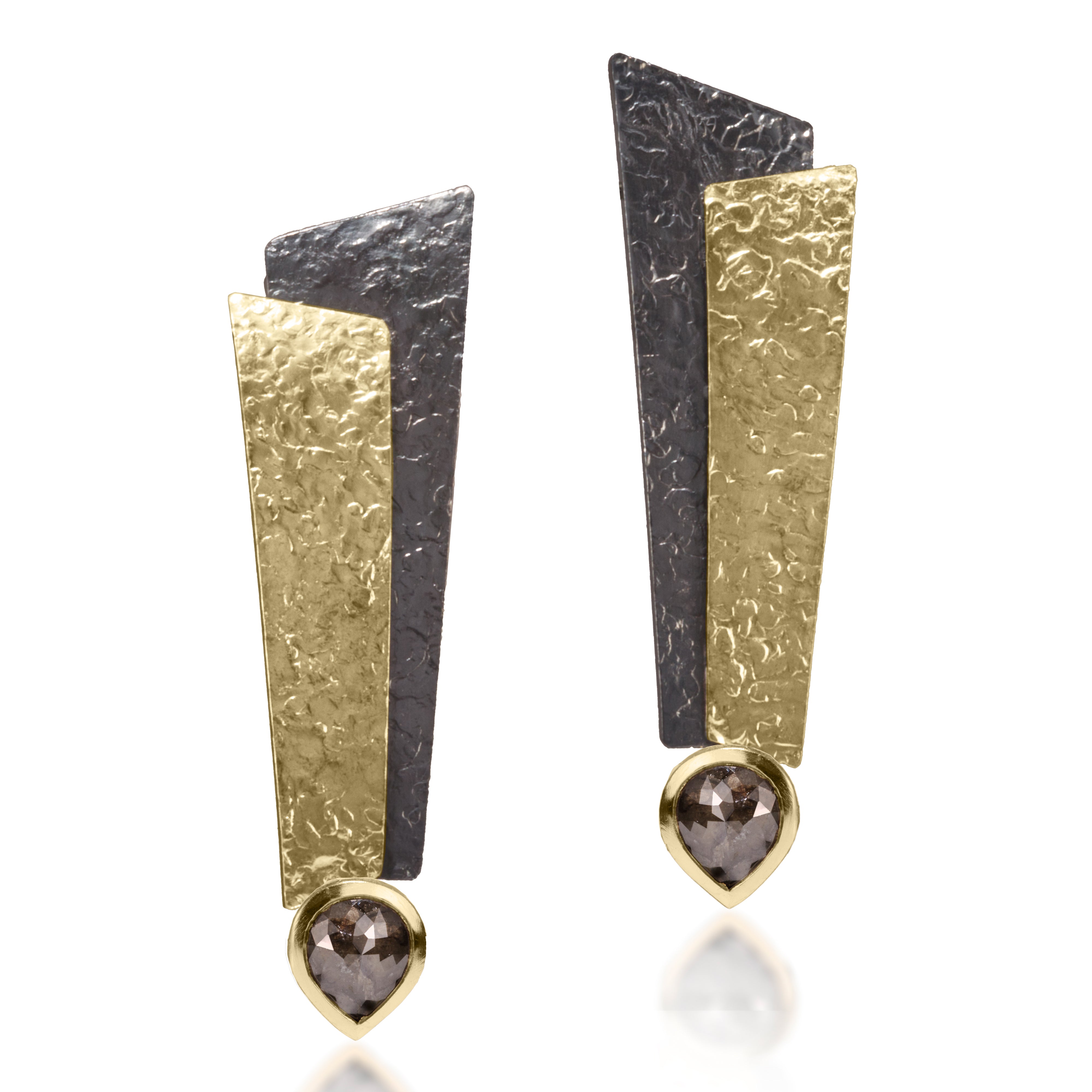 This dramatic earring has been created in 18k bi-metal and oxidized sterling silver accented with various bezel diamonds. Hand fabricated, hammer textured with house fabricated lever backs. tcw. varies by design.