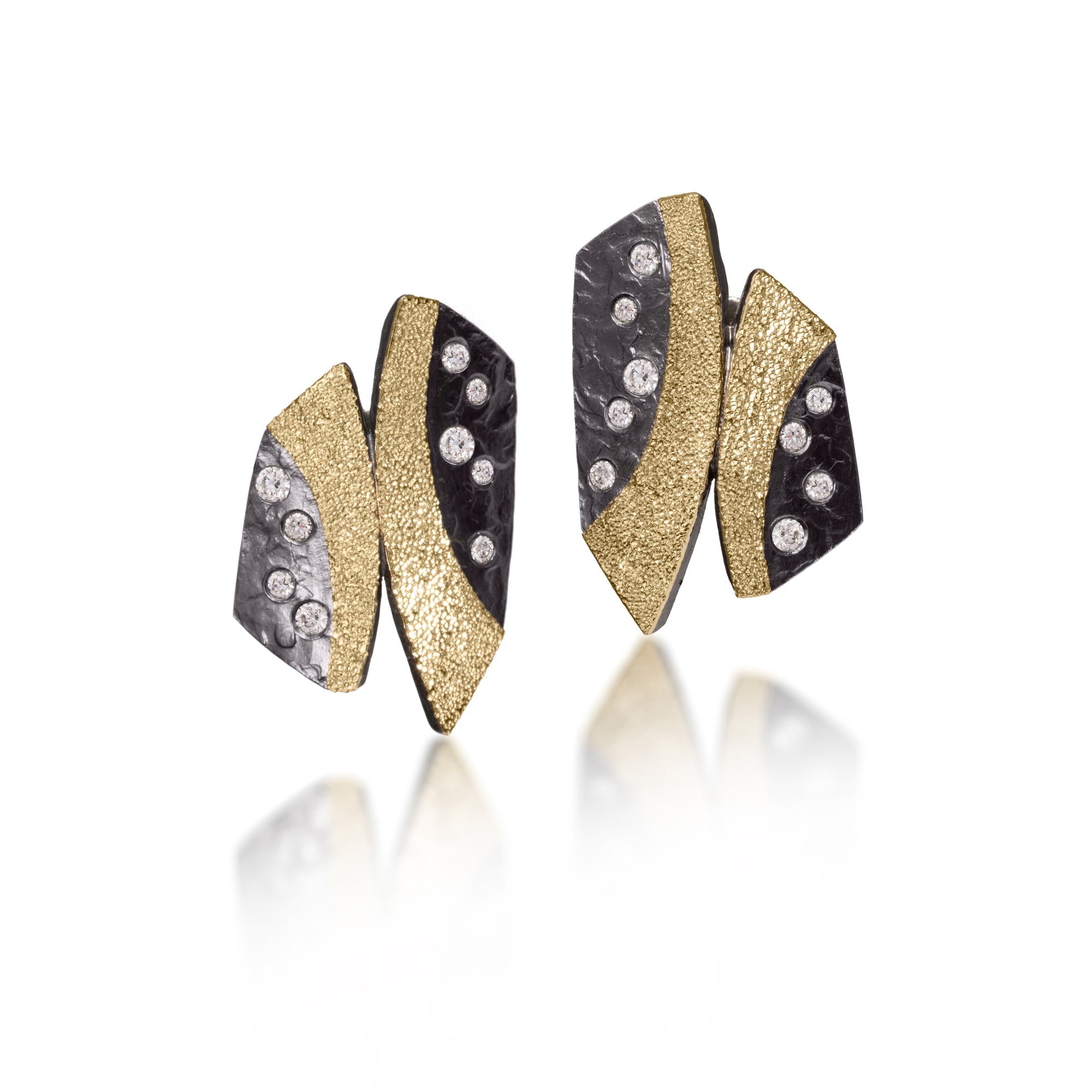 This Cyclone Earring in 18k gold and oxidized sterling silver is flush set with brilliant cut diamonds. Hand fabricated, hammer textured, diamond cut texture makes the gold shimmer. 0.41 tcw. 14k posts.