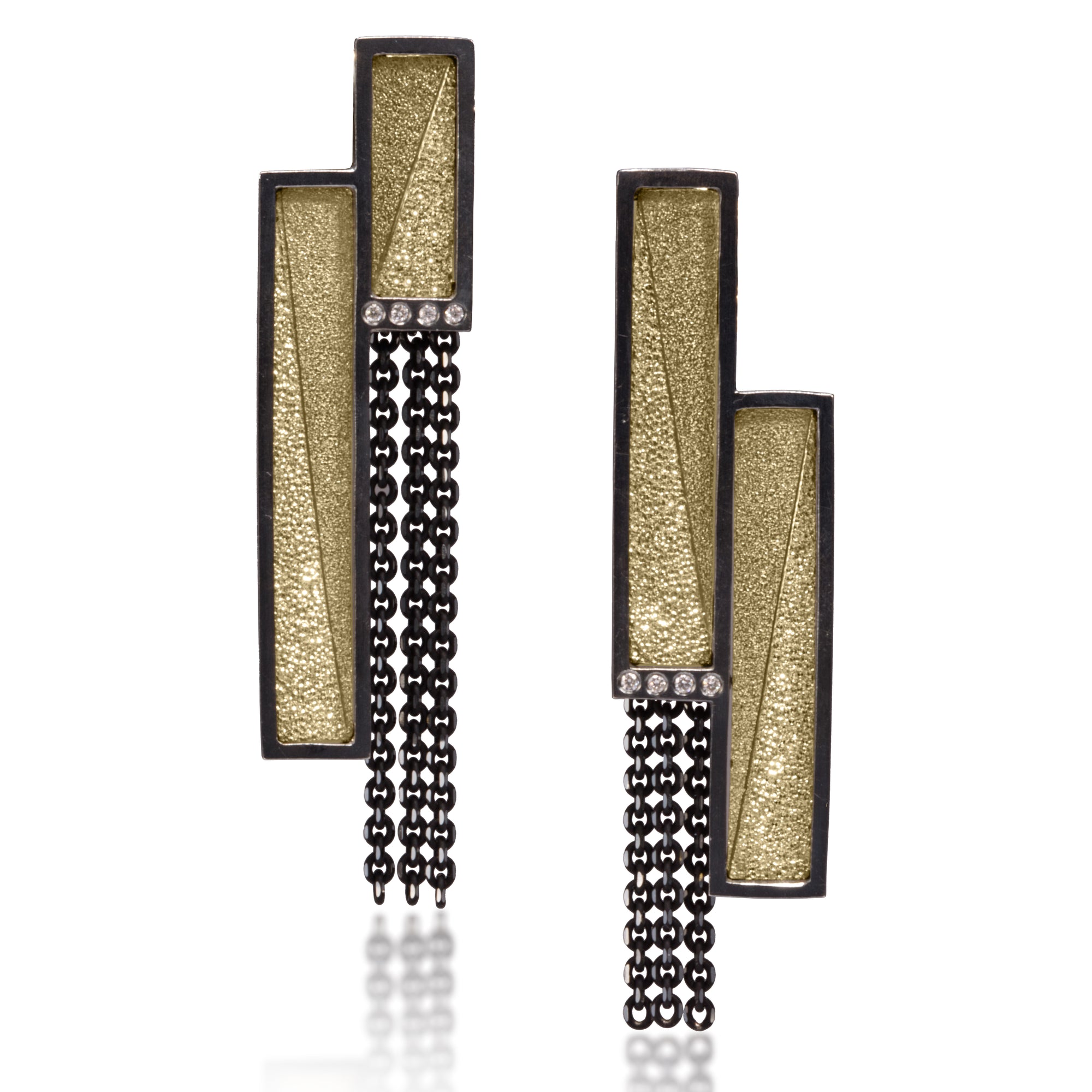 This oxidized sterling silver and richly textured 18k bimetal earring is flush set with ideal cut white diamonds.  Accent facet glitters with the texture of diamond facets, individually scored and textured.  Features 14k posts.  0.053 tcw