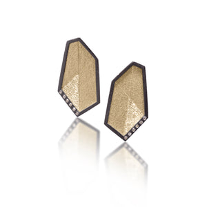 This earring is created with oxidized sterling silver and richly textured 18k bimetal, flush set with ideal cut white diamonds. It features 14k gold posts or 18k gold ear wires. Accent facet glitters with the texture of diamond facets, individually scored and textured. Elongated shape, size medium. Available in post, post fringe, drop or drop fringe styles.  0.0828 tcw
