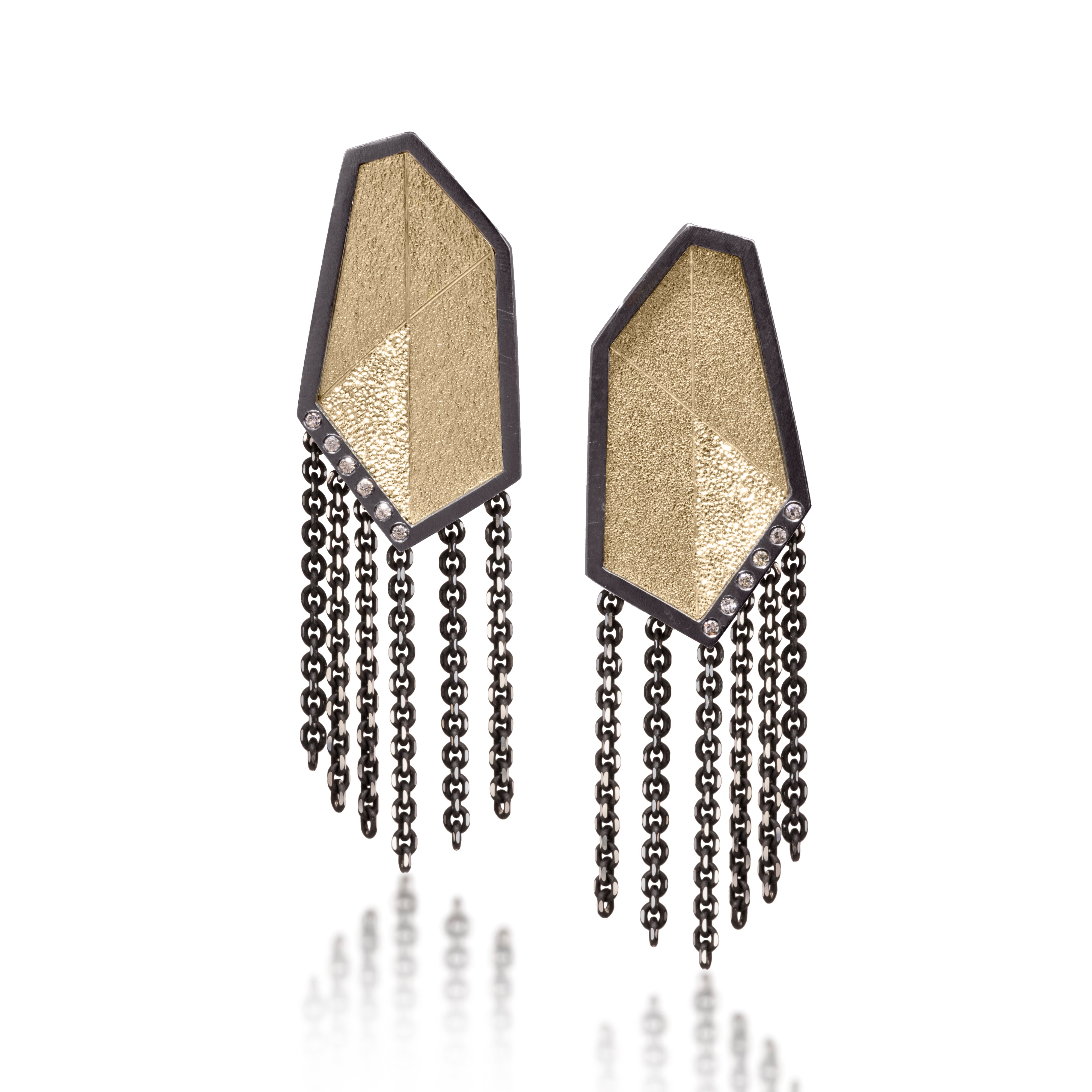 This earring is created with oxidized sterling silver and richly textured 18k bimetal, flush set with ideal cut white diamonds. It features 14k gold posts or 18k gold ear wires. Accent facet glitters with the texture of diamond facets, individually scored and textured. Elongated shape, size medium. Available in post, post fringe, drop or drop fringe styles.  0.0828 tcw