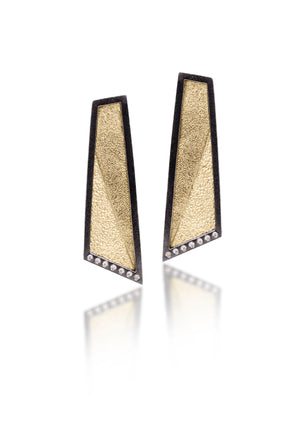 This earring in oxidized sterling silver and richly textured 18k bimetal, is flush set with ideal cut white diamonds. It features 14k gold posts or 18k gold ear wires. Accent facet glitters with the texture of diamond facets, individually scored and textured. Elongated shape, size medium. Available in post, post fringe, drop and drop fringe styles.  0.0966 tcw