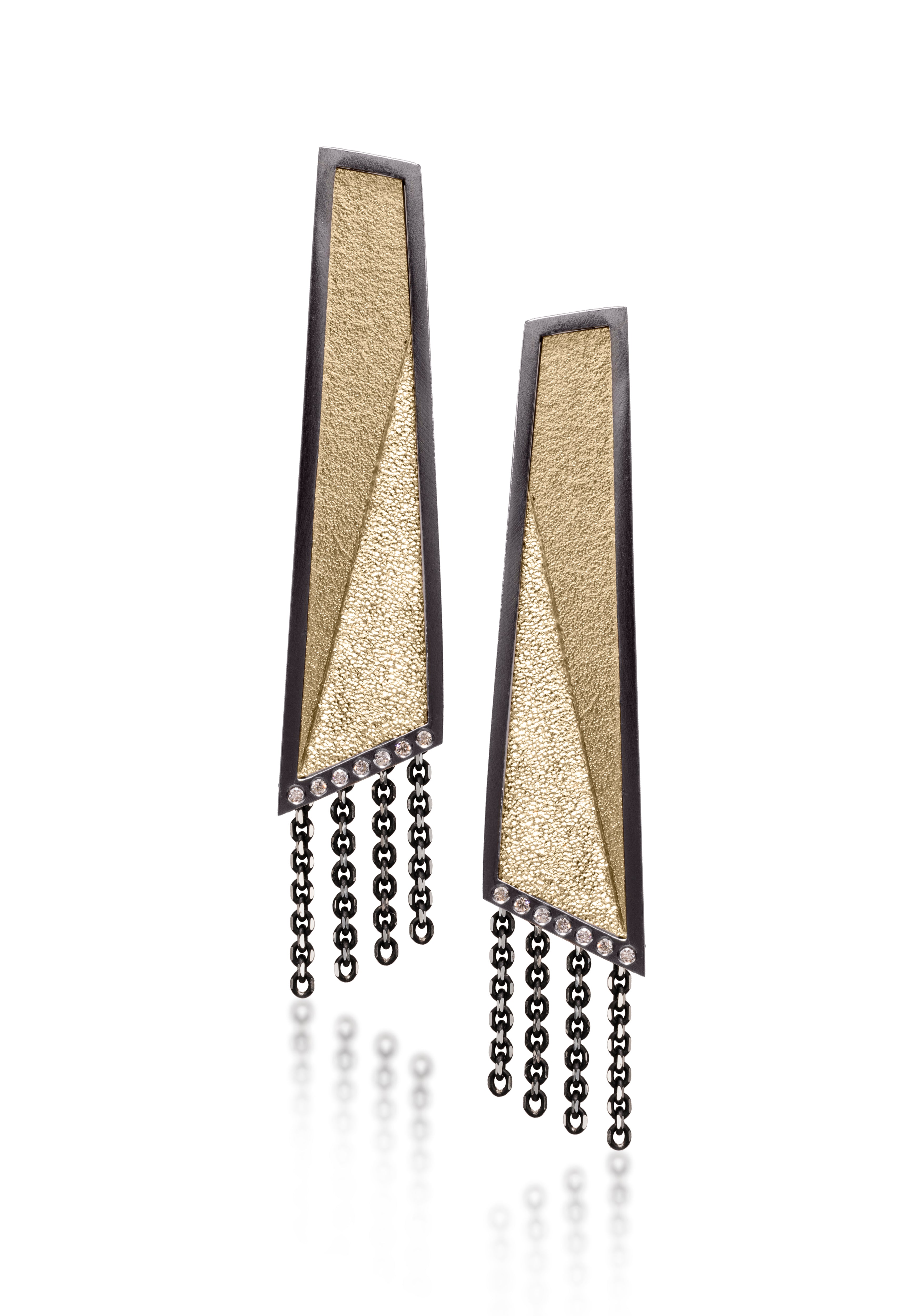 This earring in oxidized sterling silver and richly textured 18k bimetal, is flush set with ideal cut white diamonds. It features 14k gold posts or 18k gold ear wires. Accent facet glitters with the texture of diamond facets, individually scored and textured. Elongated shape, size large. Available in post, post fringe, drop and drop fringe styles.  0.0966 tcw