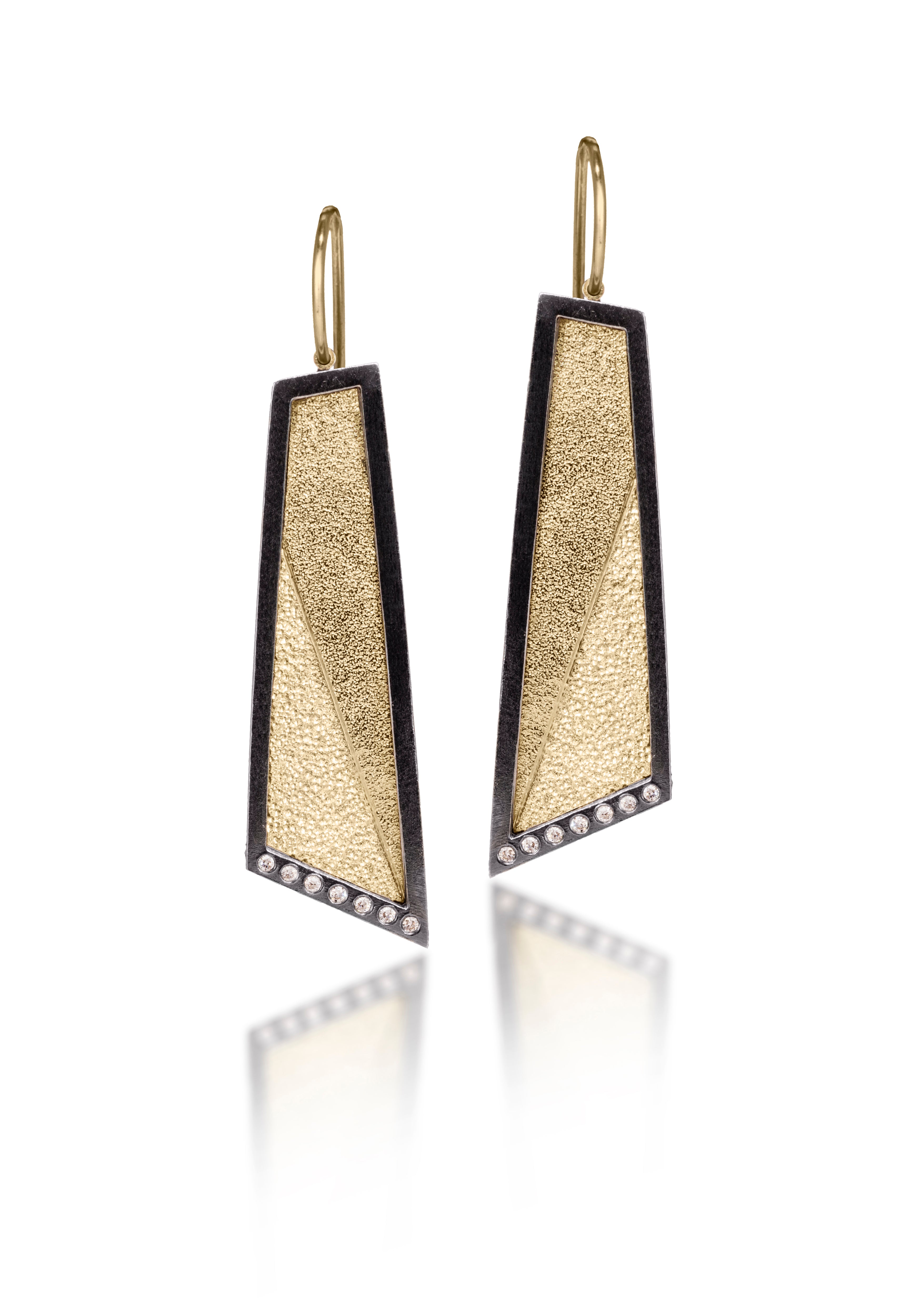 This earring in oxidized sterling silver and richly textured 18k bimetal, is flush set with ideal cut white diamonds. It features 14k gold posts or 18k gold ear wires. Accent facet glitters with the texture of diamond facets, individually scored and textured. Elongated shape, size medium. Available in post, post fringe, drop and drop fringe styles.  0.0966 tcw