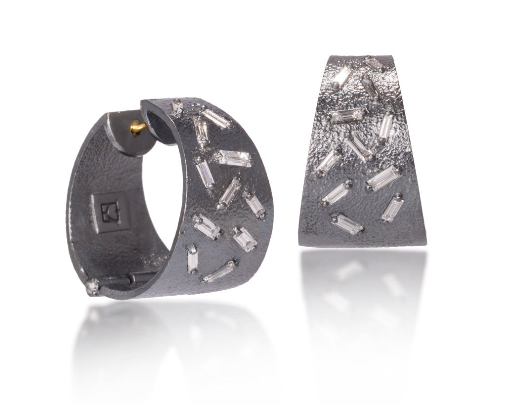 These all in one huggie style earrings are each set with 11 white diamond baguettes. This smaller huggie option earring is available in three richly textured color ways, oxidized sterling, 18k gold and palladium.  .696 tcw.  