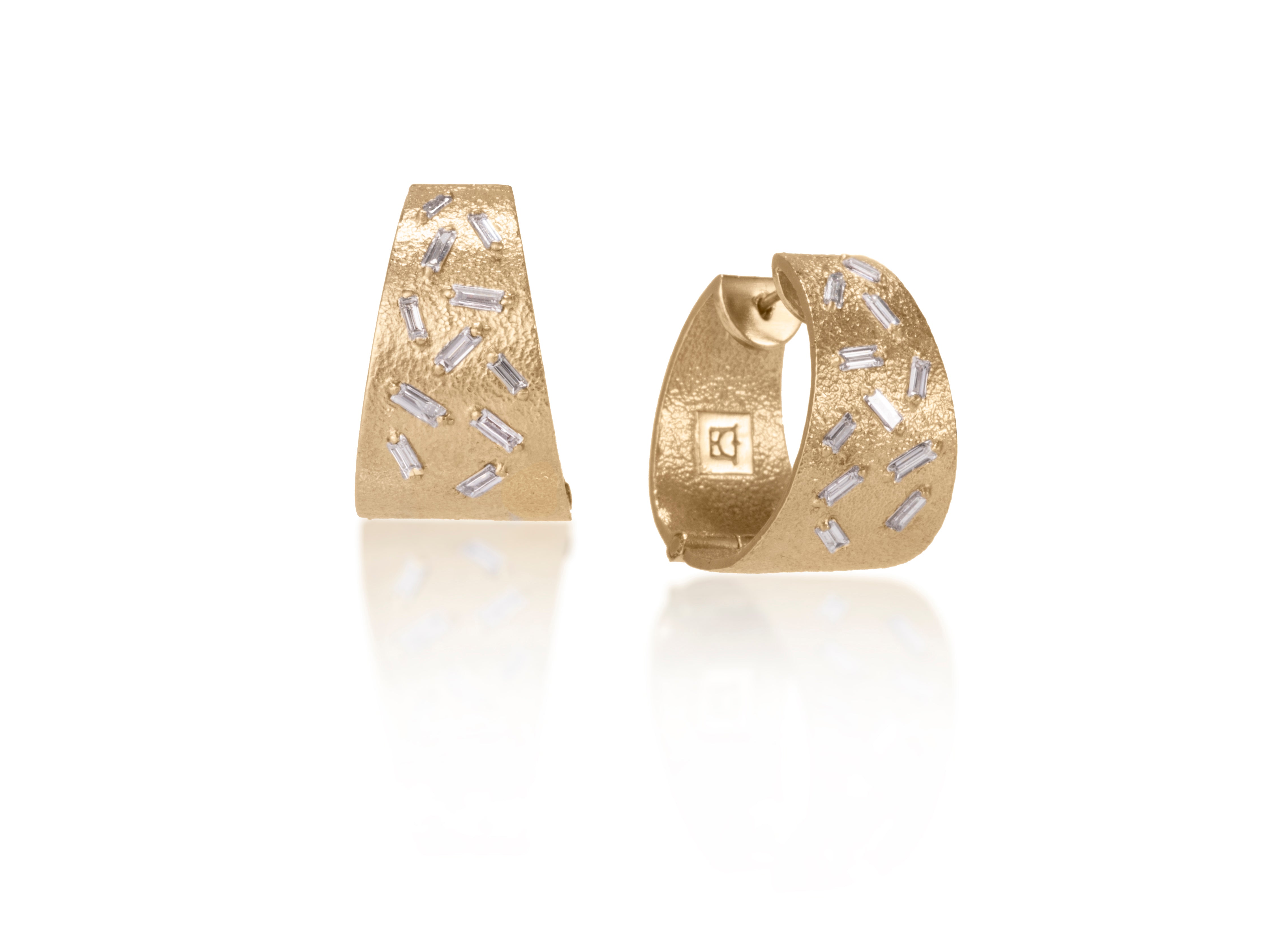 These all in one huggie style earrings are each set with 11 white diamond baguettes. This smaller huggie option earring is available in three richly textured color ways, oxidized sterling, 18k gold and palladium.  .696 tcw.  
