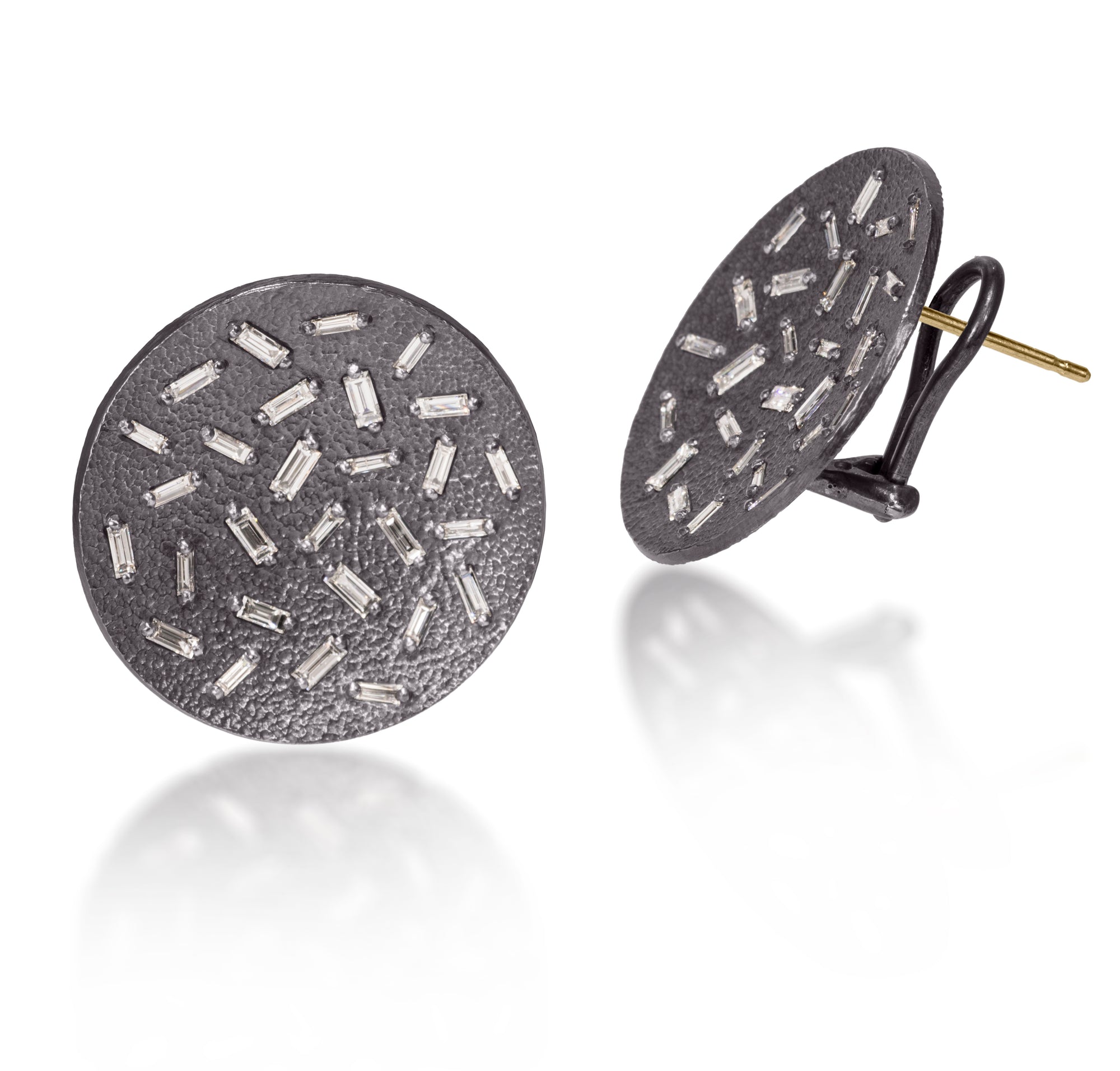 This simple but dramatic post earring is perfect for everyday or a fabulous night out.  Offered in three richly textured color ways, oxidized sterling, 18k gold, palladium.  Each earring set with 28 white diamond baguettes.  18k post features an omega back for added support. 1.546 tcw.