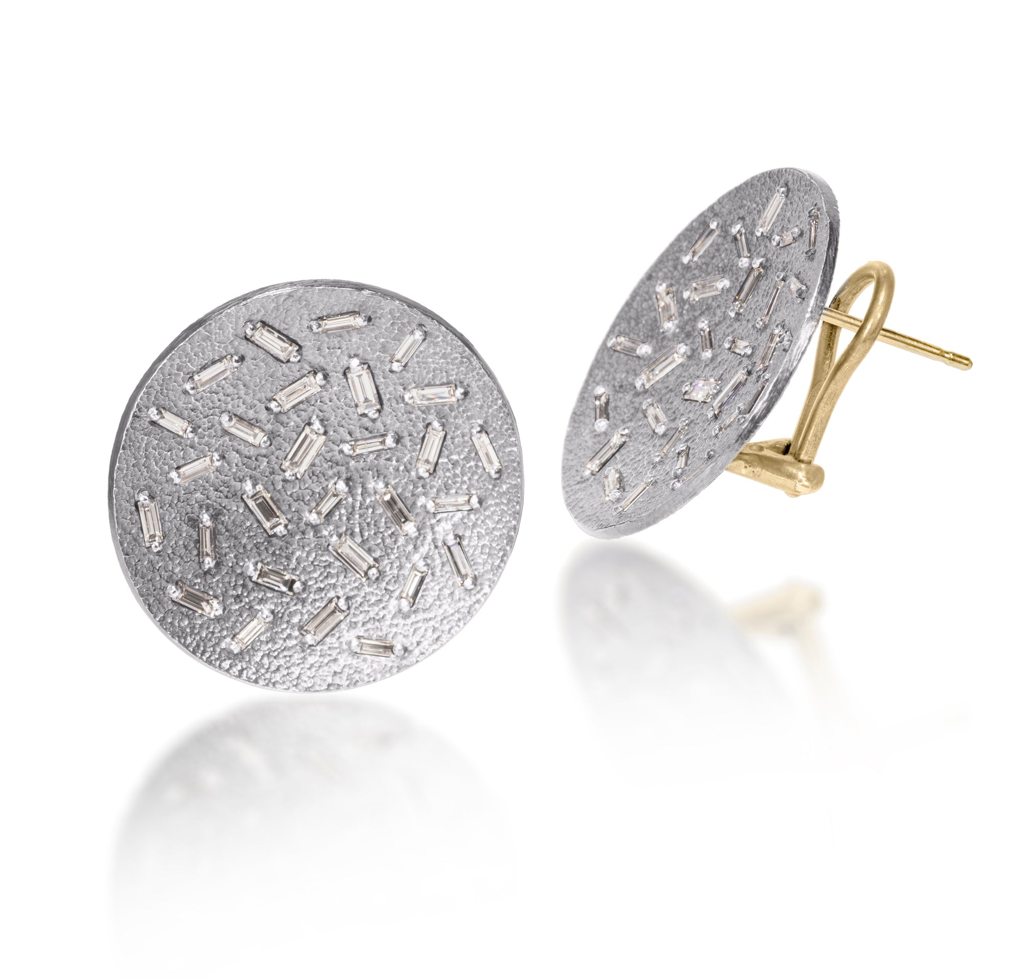 This simple but dramatic post earring is perfect for everyday or a fabulous night out.  Offered in three richly textured color ways, oxidized sterling, 18k gold, palladium.  Each earring set with 28 white diamond baguettes.  18k post features an omega back for added support. 1.546 tcw.