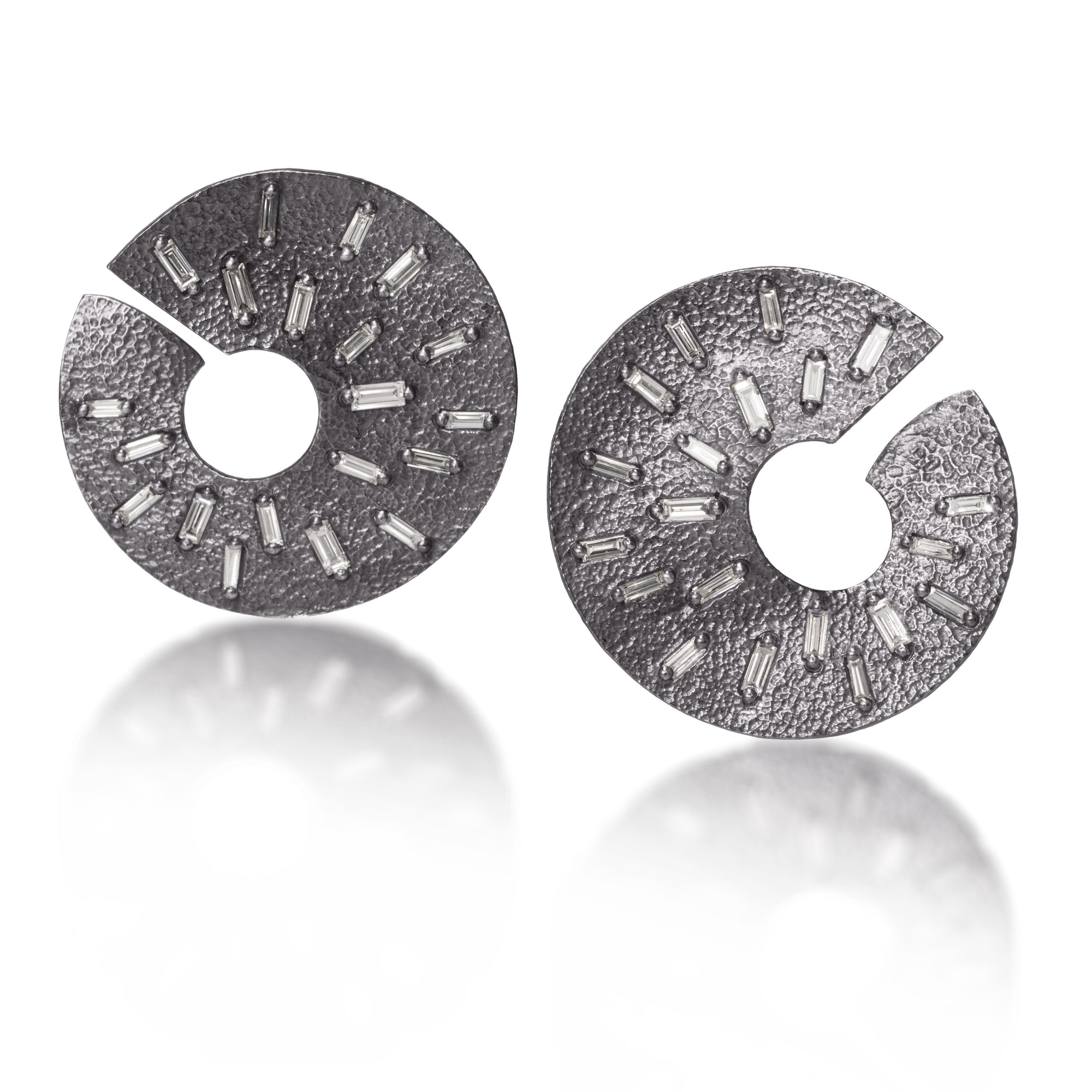 The smaller of two radiant styled earrings, each set with 21 white diamond baguettes. Richly textured and designed to three dimensionally wrap around from the front to behind the ear.  It is available in three color ways, oxidized silver, 18k gold and palladium.  1.176 tcw.