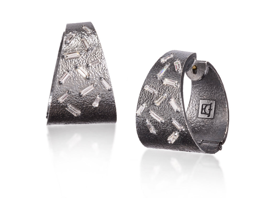 This larger huggie style earring is created in richly textured oxidized sterling, each set with 12 white diamond baguettes. 0.7423 tcw.  