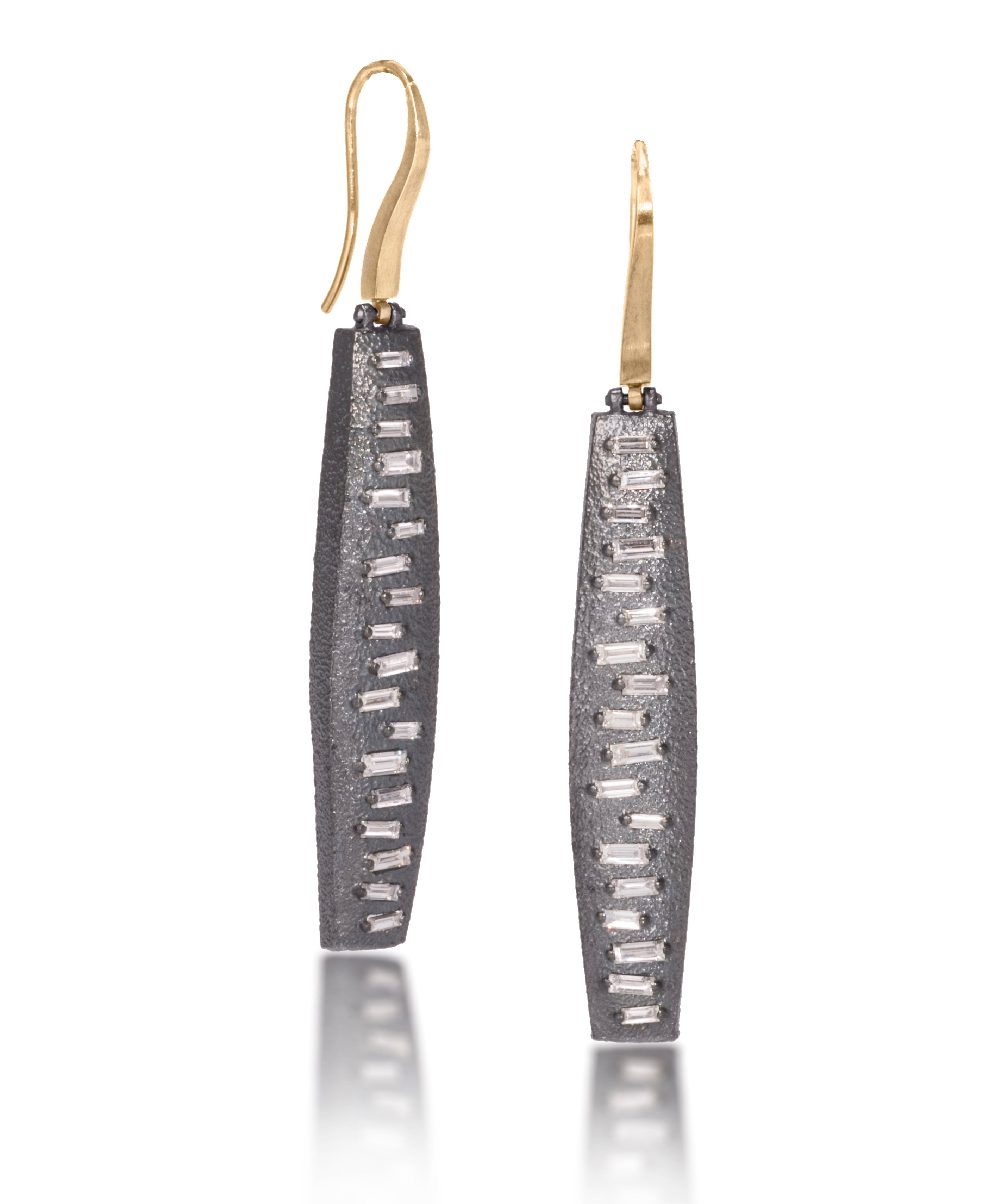 This earring features a hinged earwire, with a graceful, curved and tapered form. The playful irregularity of the baguette angles catch the light in dynamic ways. Design is offered in four richly textured colorways, oxidized sterling, oxidized sterling/18k gold, 18k gold and palladium.  Each earring set with 36 total white diamond baguettes. 1.1104 tcw.