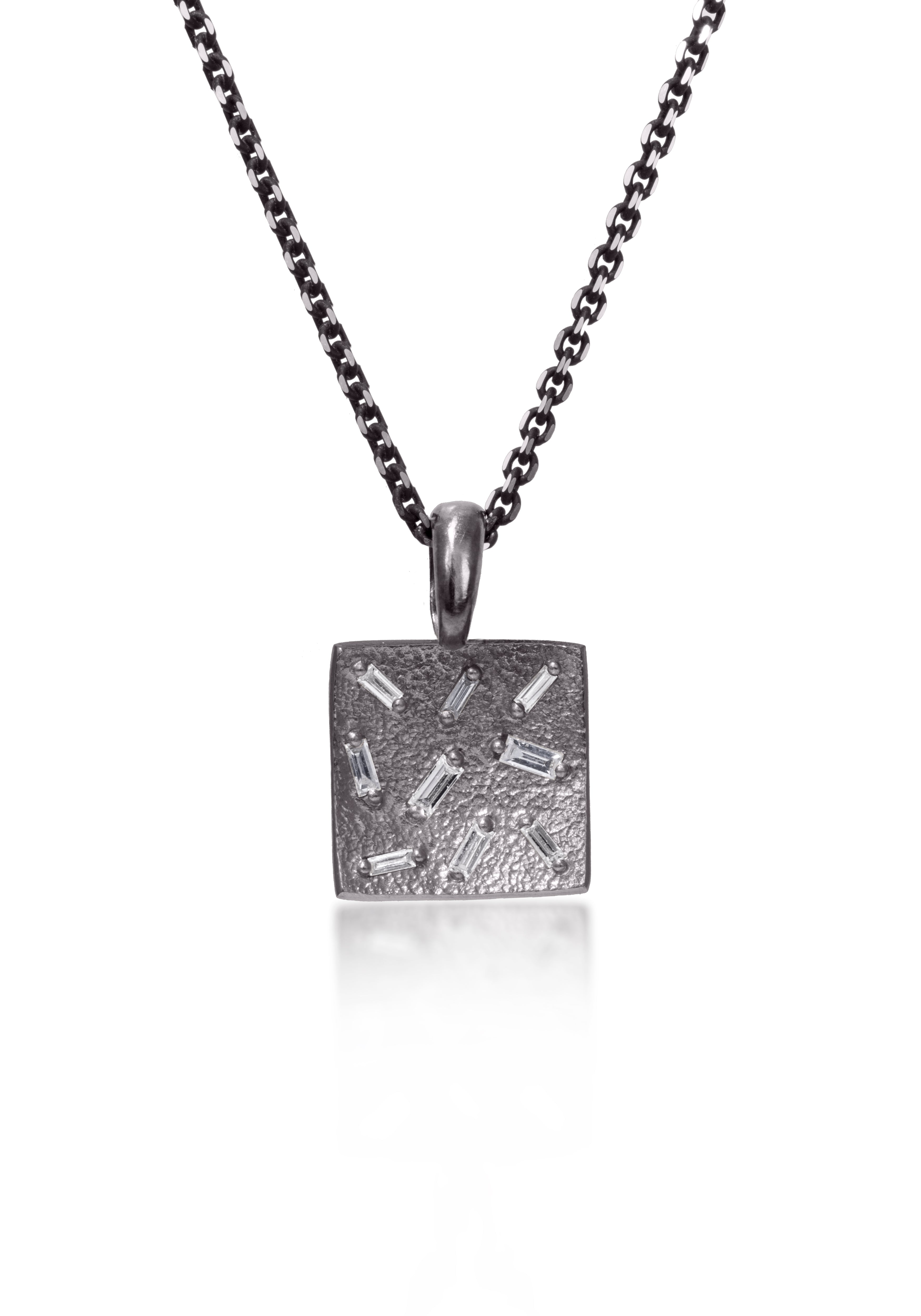 This stunning, small square pendant is set with 9 white diamond baguettes. Richly textured to shimmer in the light, this piece is available in three color ways, oxidized silver, 18k gold and palladium (pictured).  0.245 tcw.