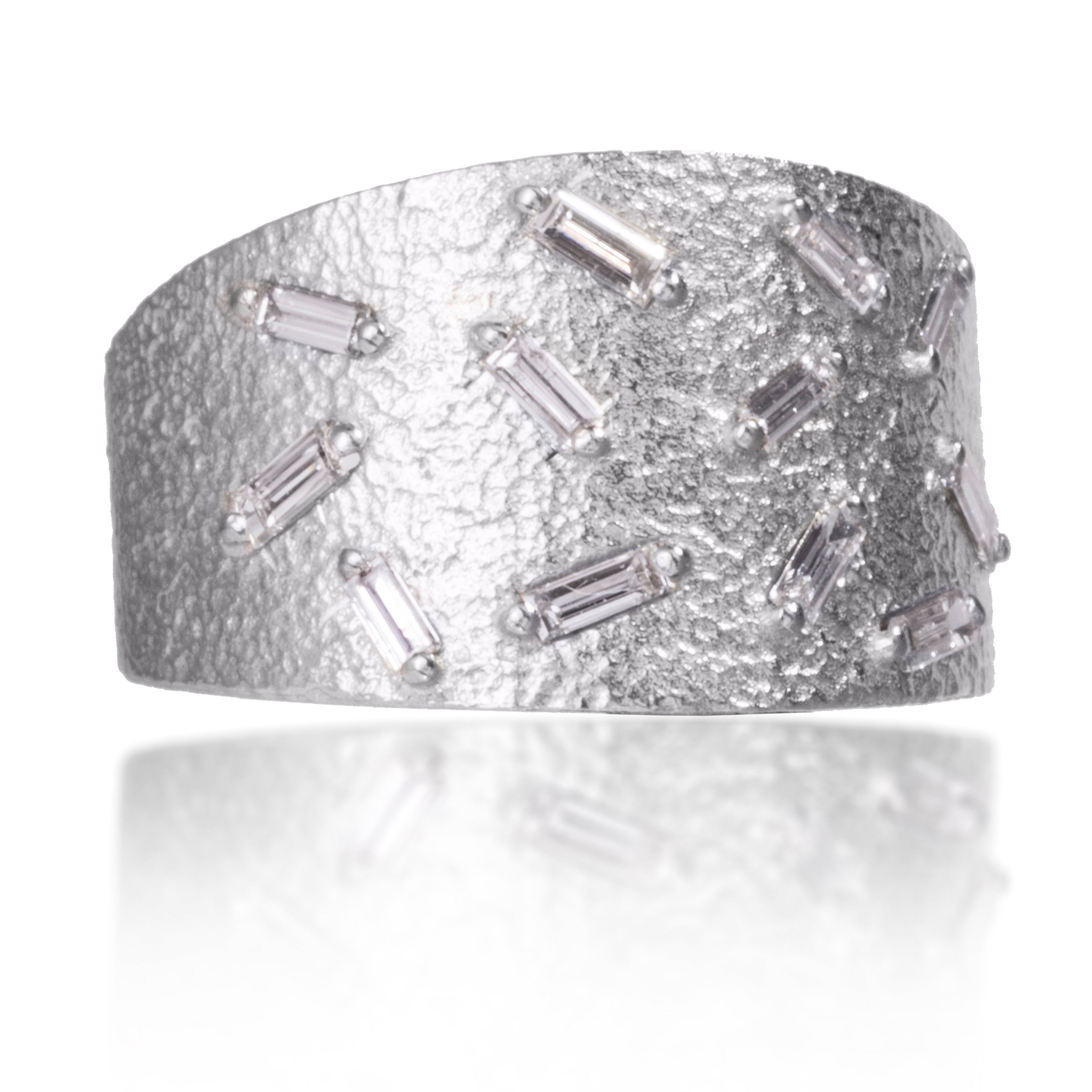 This medium width cigar band style ring is set with 12 white diamond baguettes. It is available in three richly textured color ways, oxidized silver, 18k gold, and palladium. Makes a beautiful bridal alternative. 0.4023 tcw. 