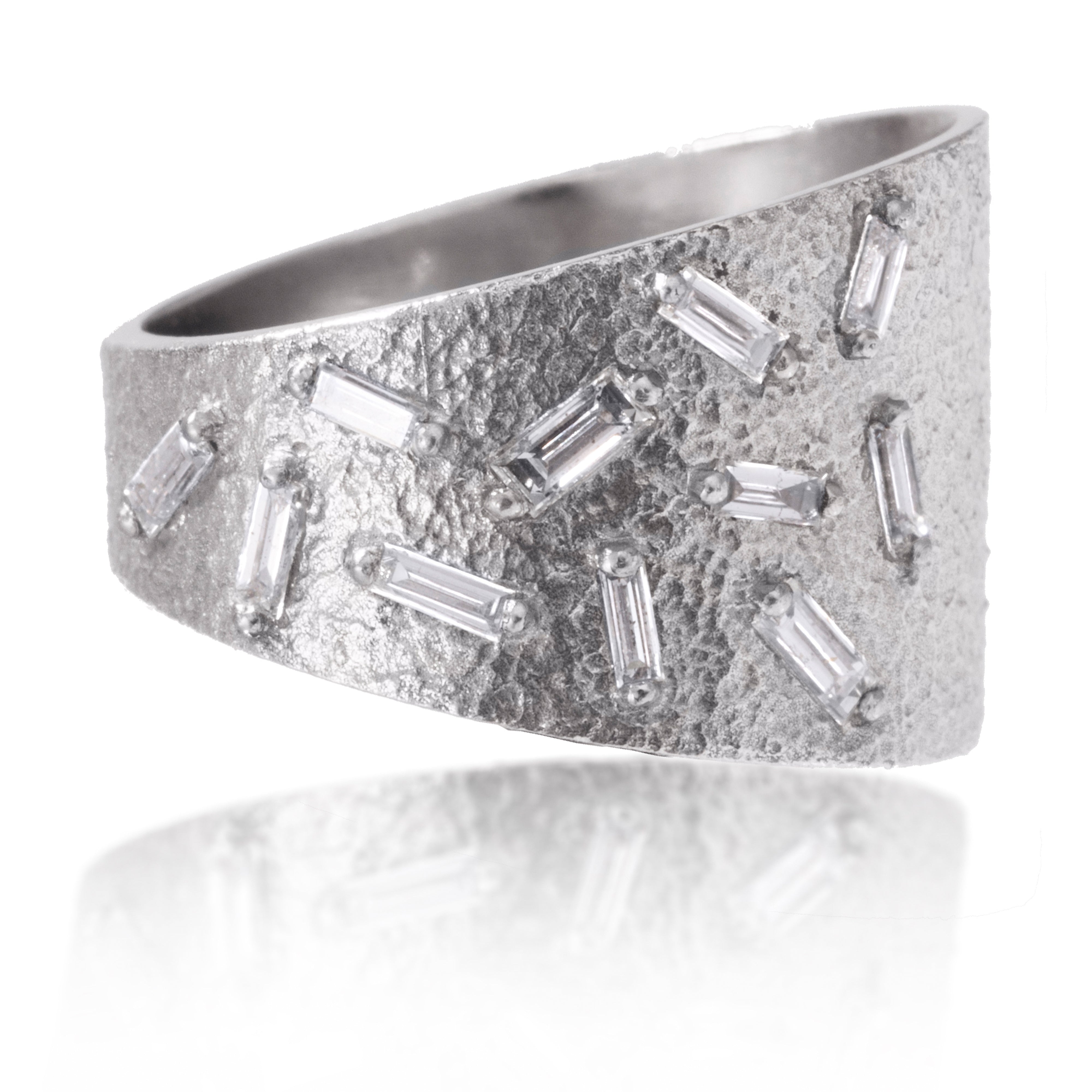 This tapered wedge style ring is set with 11 white diamond baguettes.  It is available in three richly textured color ways, oxidized silver, 18k gold and palladium. 0.36 tcw.