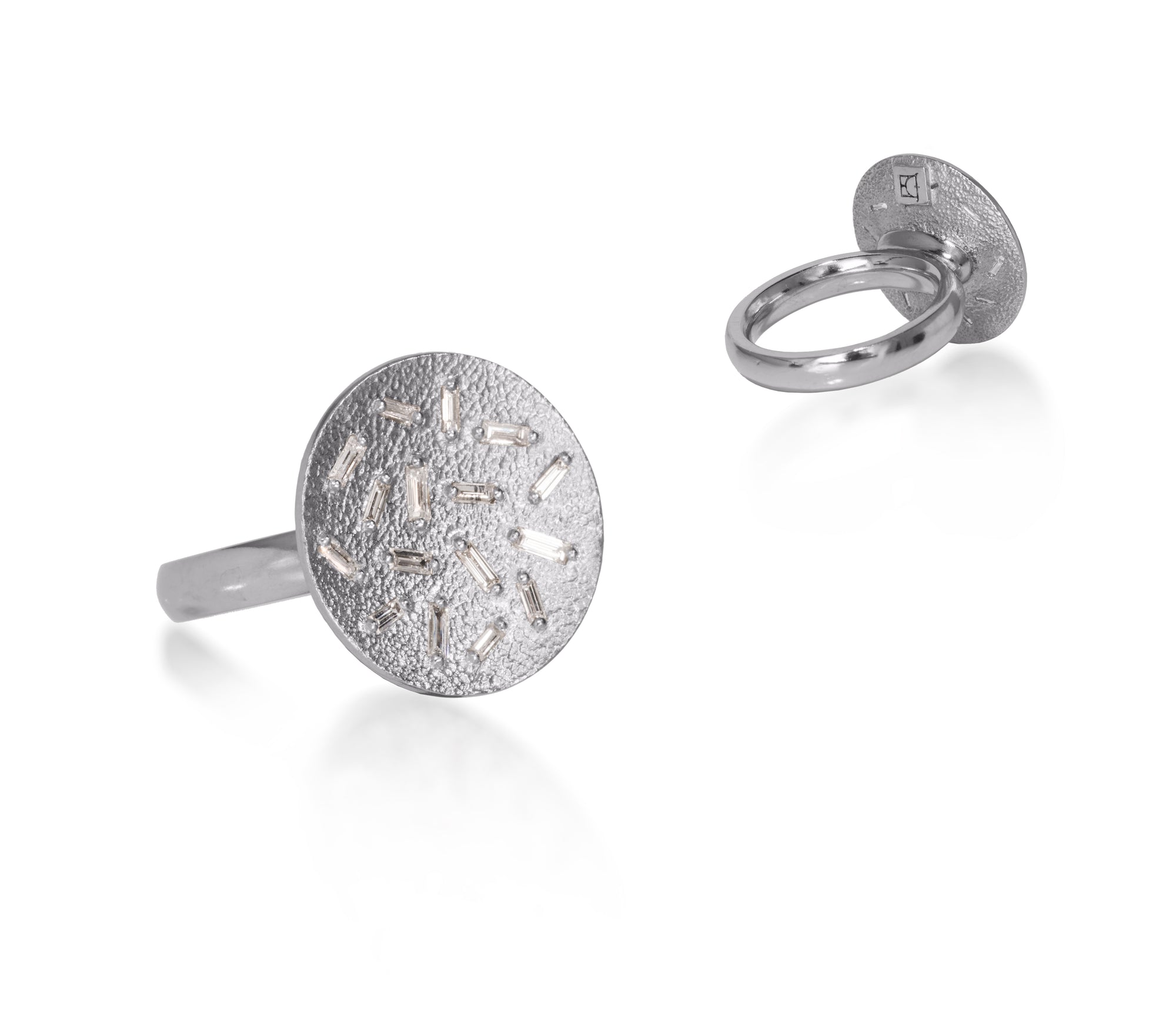 This medium circular pendant ring is set with 16 white diamond baguettes. It is available in three richly textured color ways, oxidized silver, 18k gold and palladium.  The random angles of the baguettes catch the light in exciting ways when worn. 0.435 tcw.