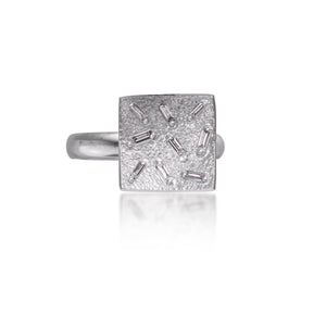 This small square pendant ring is set with 9 white diamond baguettes. It is available in three richly textured color ways, oxidized silver, 18k gold and palladium. The random angles of the baguettes catch the light in exciting ways when worn. 0.25 tcw.