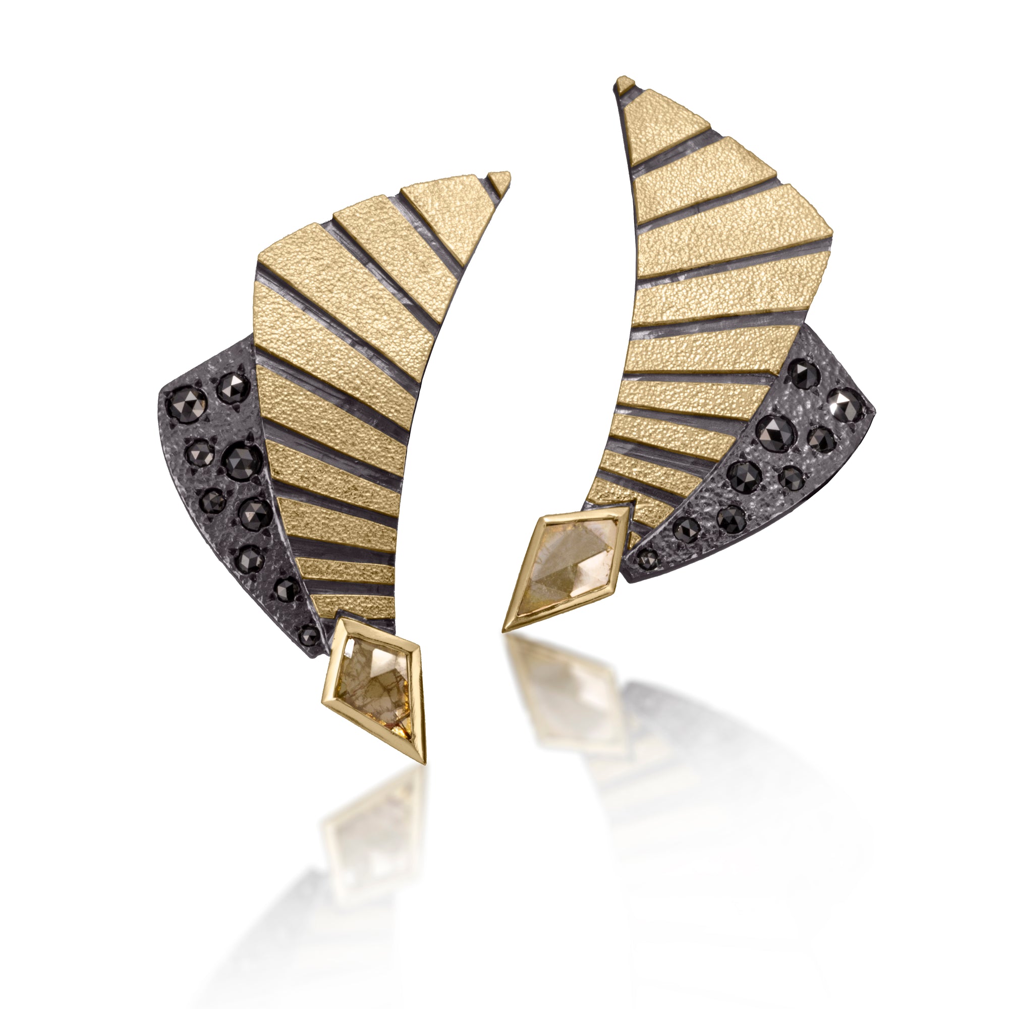 With their energetic gesture and elegant curve, this one of a kind variation of Stripe E9 will put a point on any outfit. Hand fabricated, stipple textured and engraved mixed metals, with 14k gold posts. These post earrings are playfully graphic with an oxidized accent, set with black diamonds and golden yellow diamond shaped diamond slices.